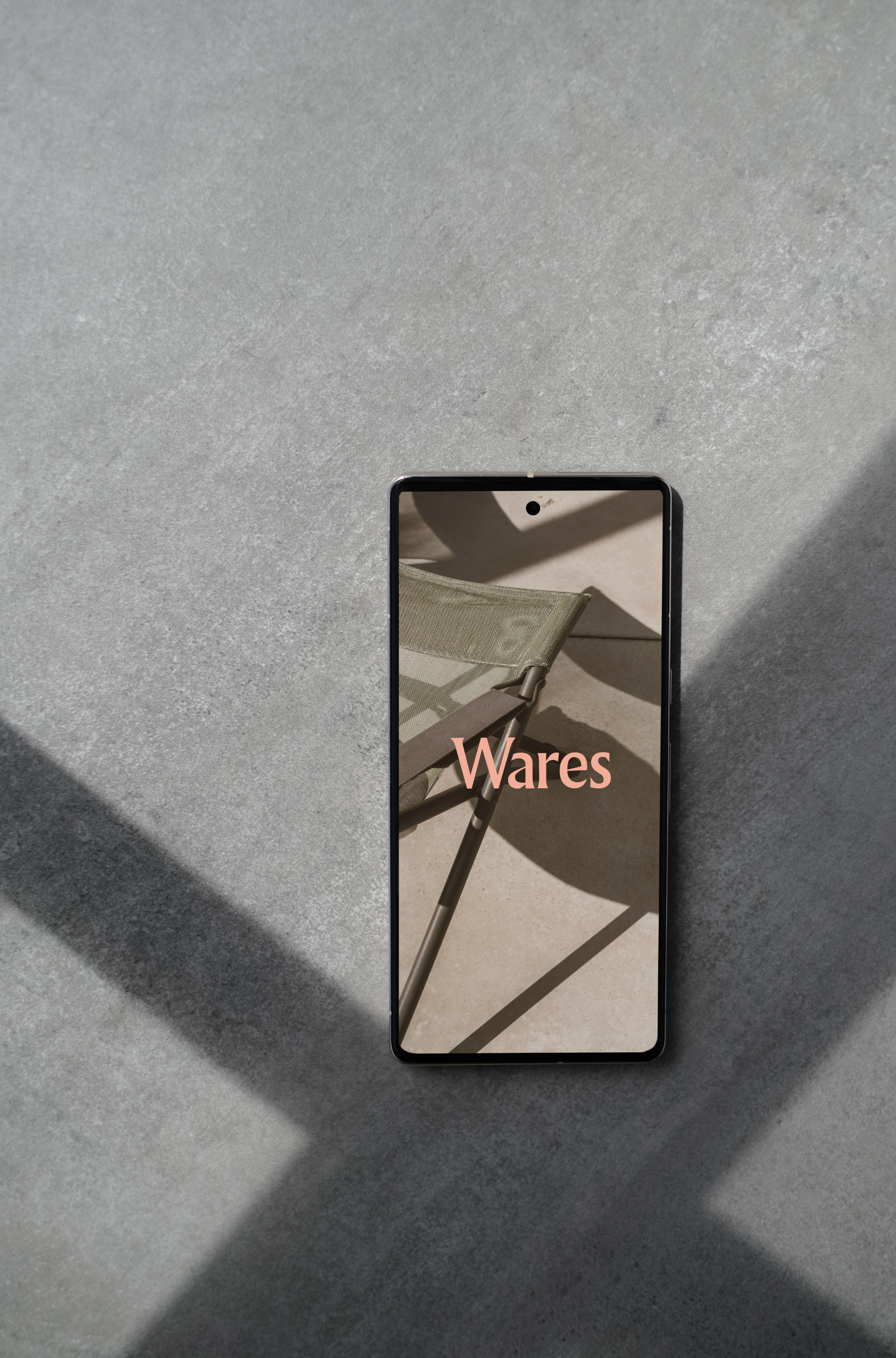 Smartphone on concrete surface displaying 'Wares' with image of a chair.