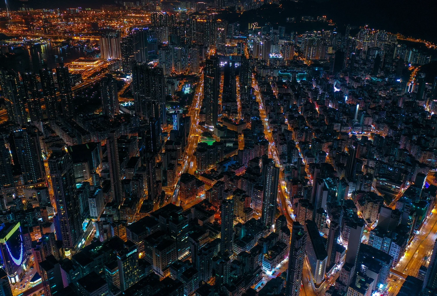 Aerial night view of a dense lit-up street grid in Hong Kong