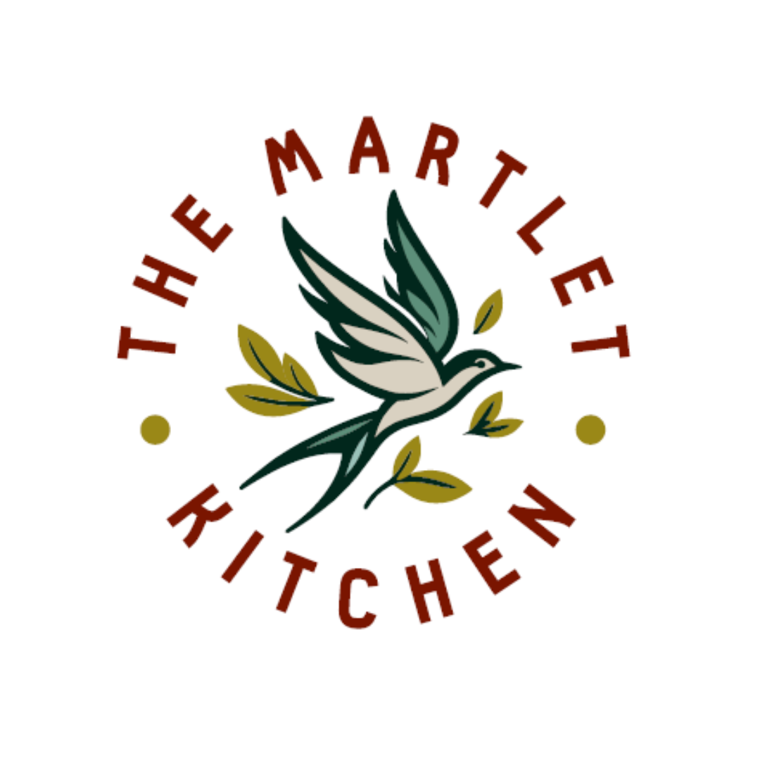 A logo featuring a stylized white and teal bird in flight with olive branches, surrounded by the text 'The Marlet Kitchen' in red and small yellow dots.