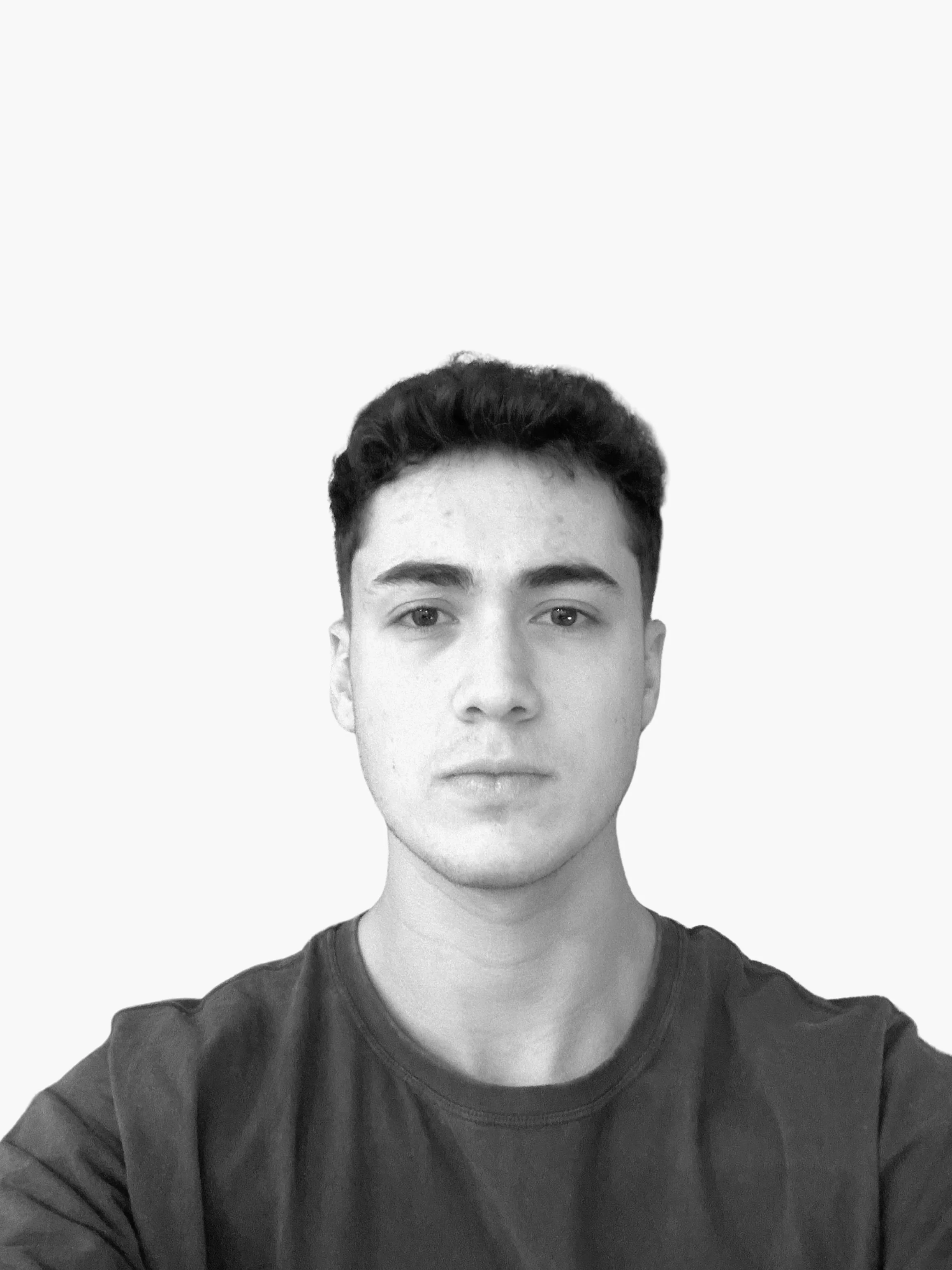 A young man with short dark hair and light skin facing the camera with a neutral expression, wearing a dark brown shirt, against a plain white background.