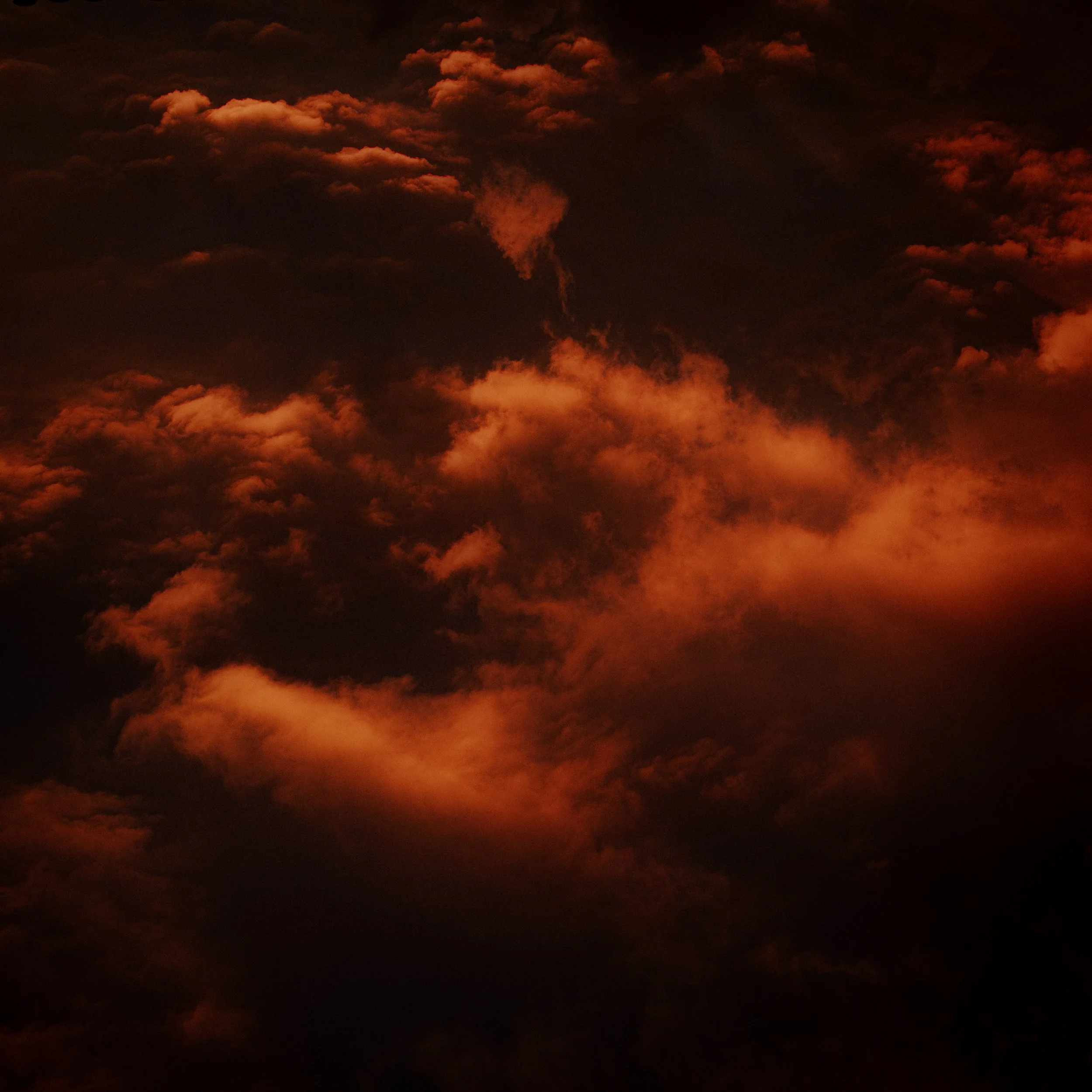 Nuages sombres éclairés par une lueur rouge-orange.