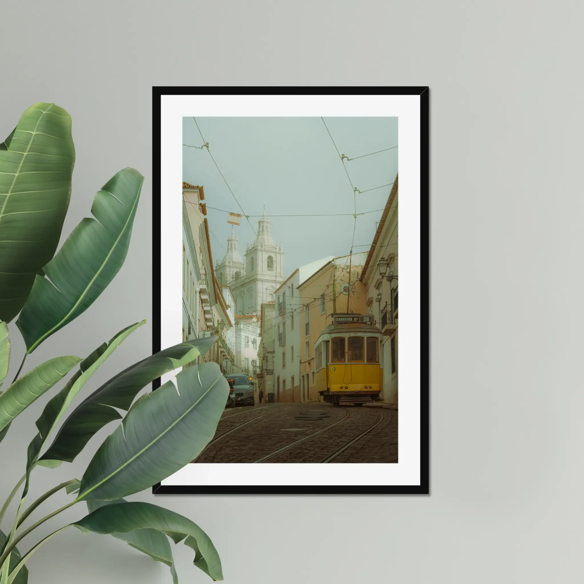 ejduranphotography Fine Art Lisbon print. Cinematic street photography of the iconic yellow Tram 28 on a winding cobblestone street with a misty church background. Moody wall art decor.