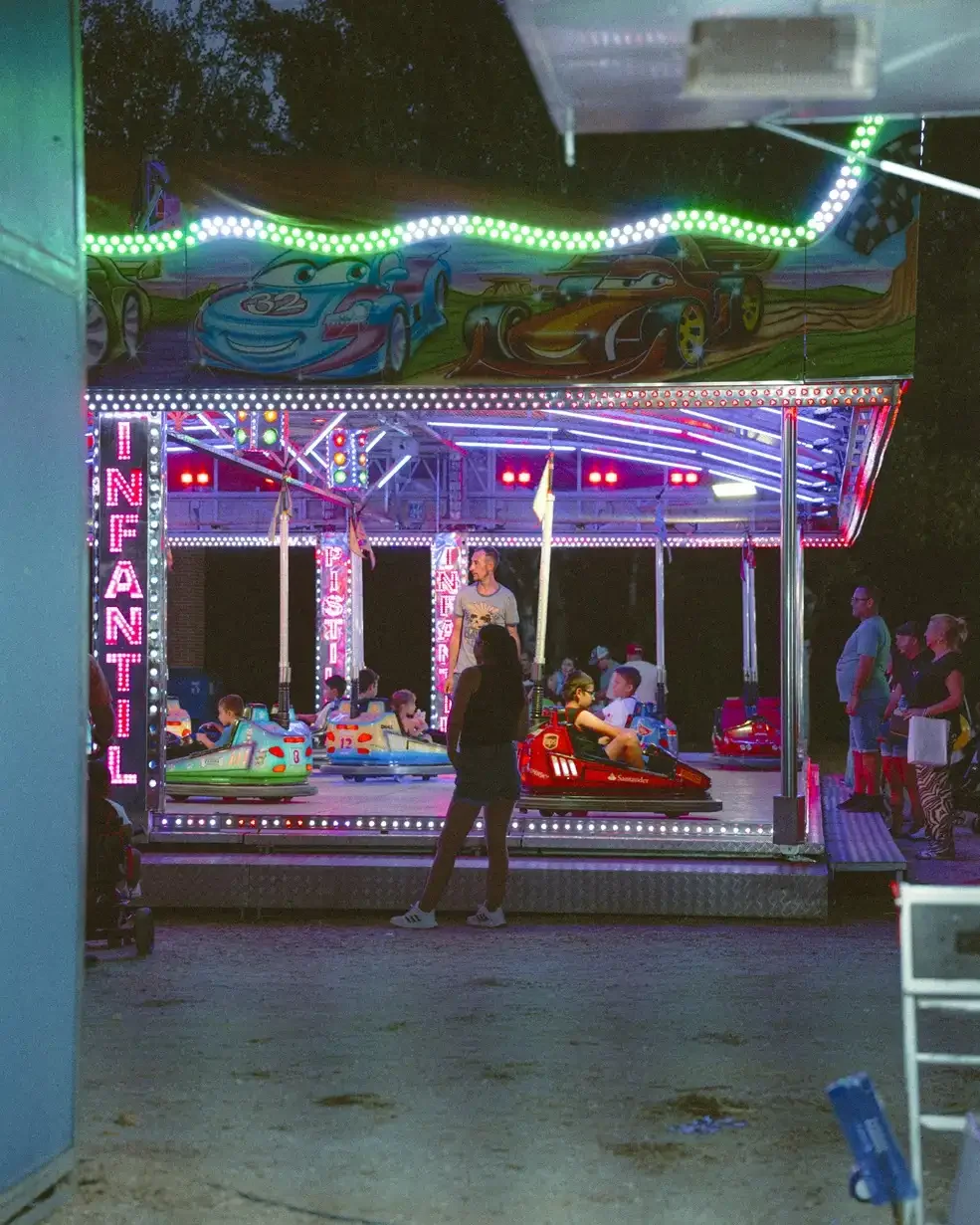 Before and after comparison using Lomography 800 Lightroom preset on a night street photography scene with vibrant neon lights and film grain.