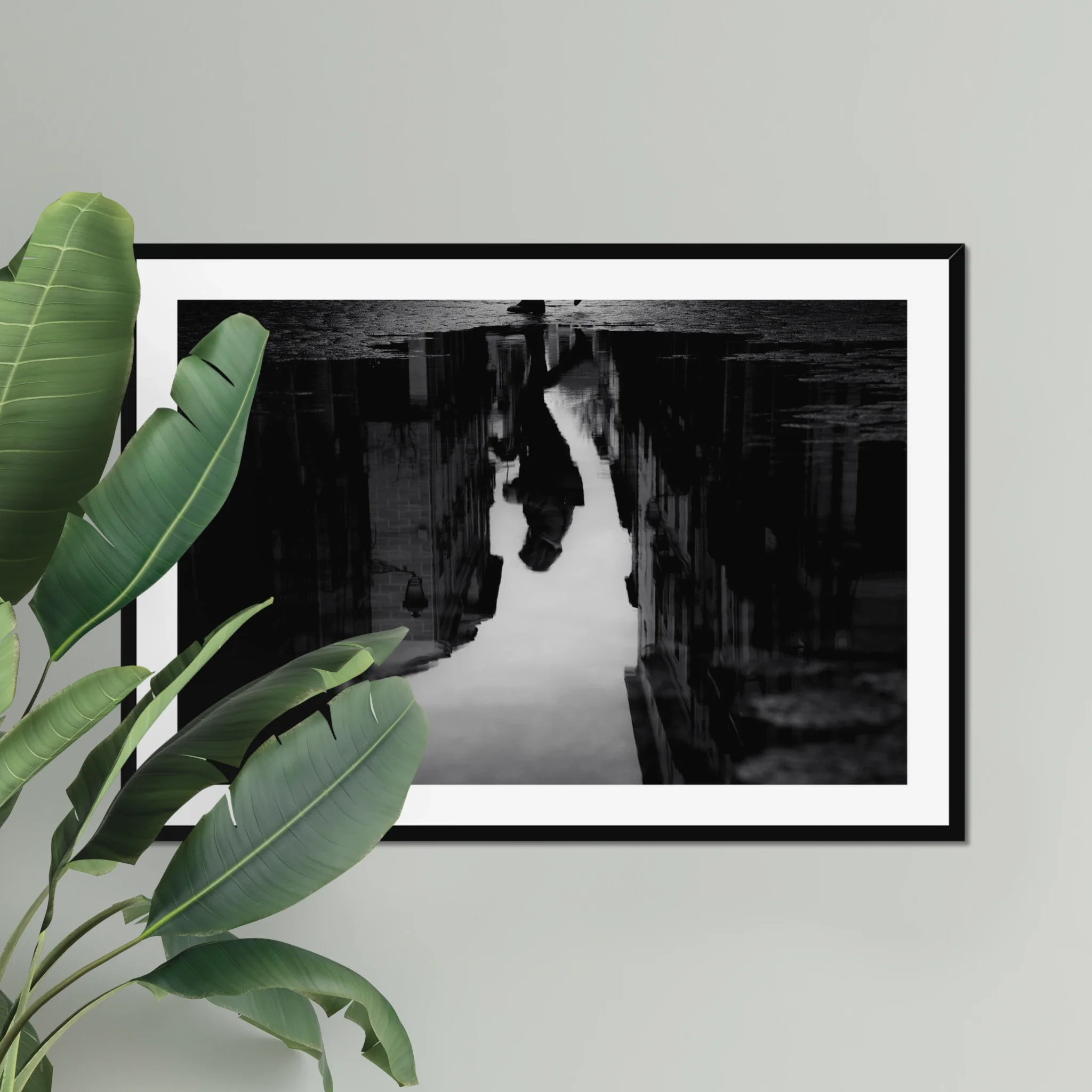 Black and white moody street photography print of a person with an umbrella walking in the rain. Features a striking reflection on wet pavement. Cinematic fine art wall decor.
