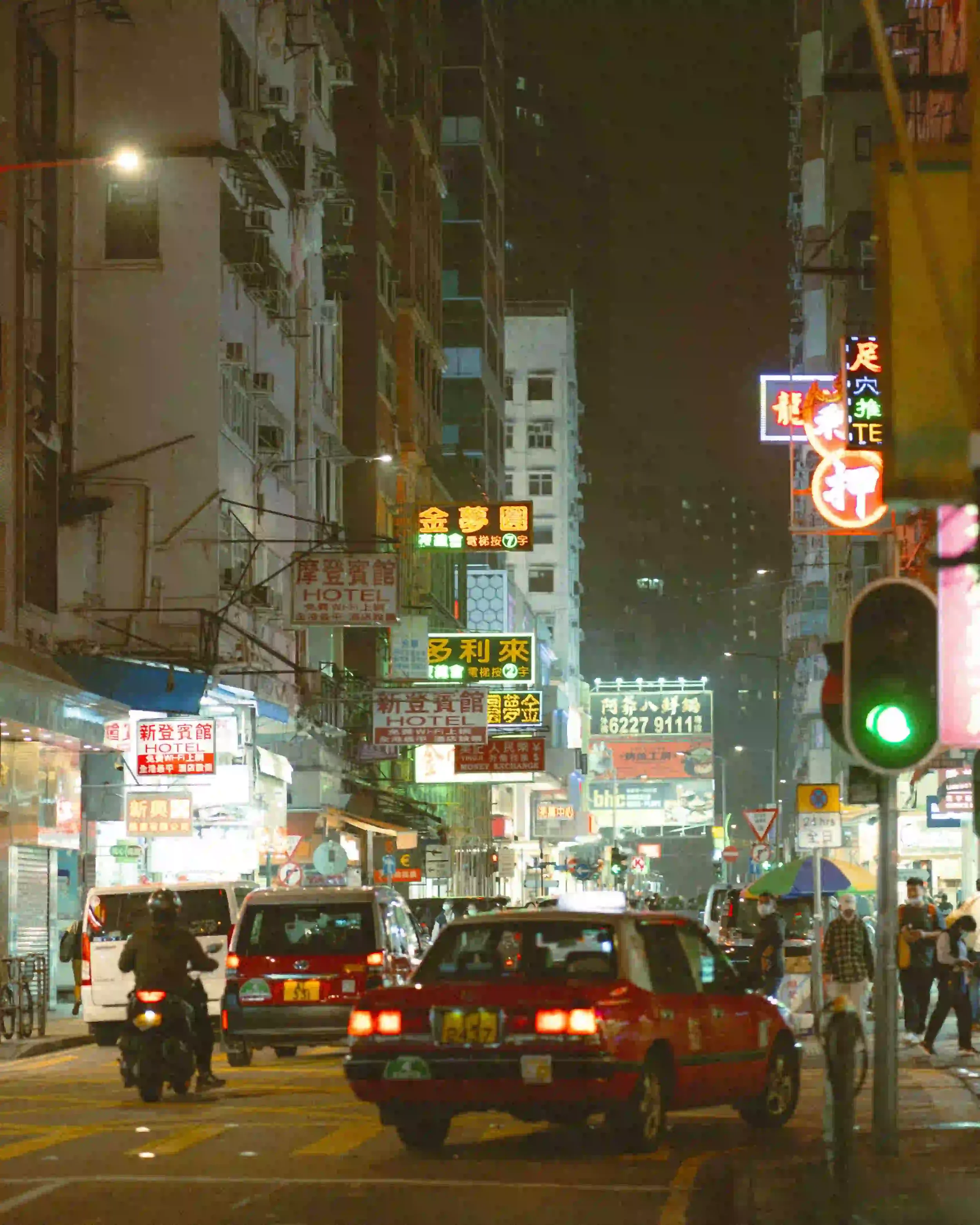 Before and after comparison using Lomography 800 Lightroom preset on a night street photography scene with vibrant neon lights and film grain.