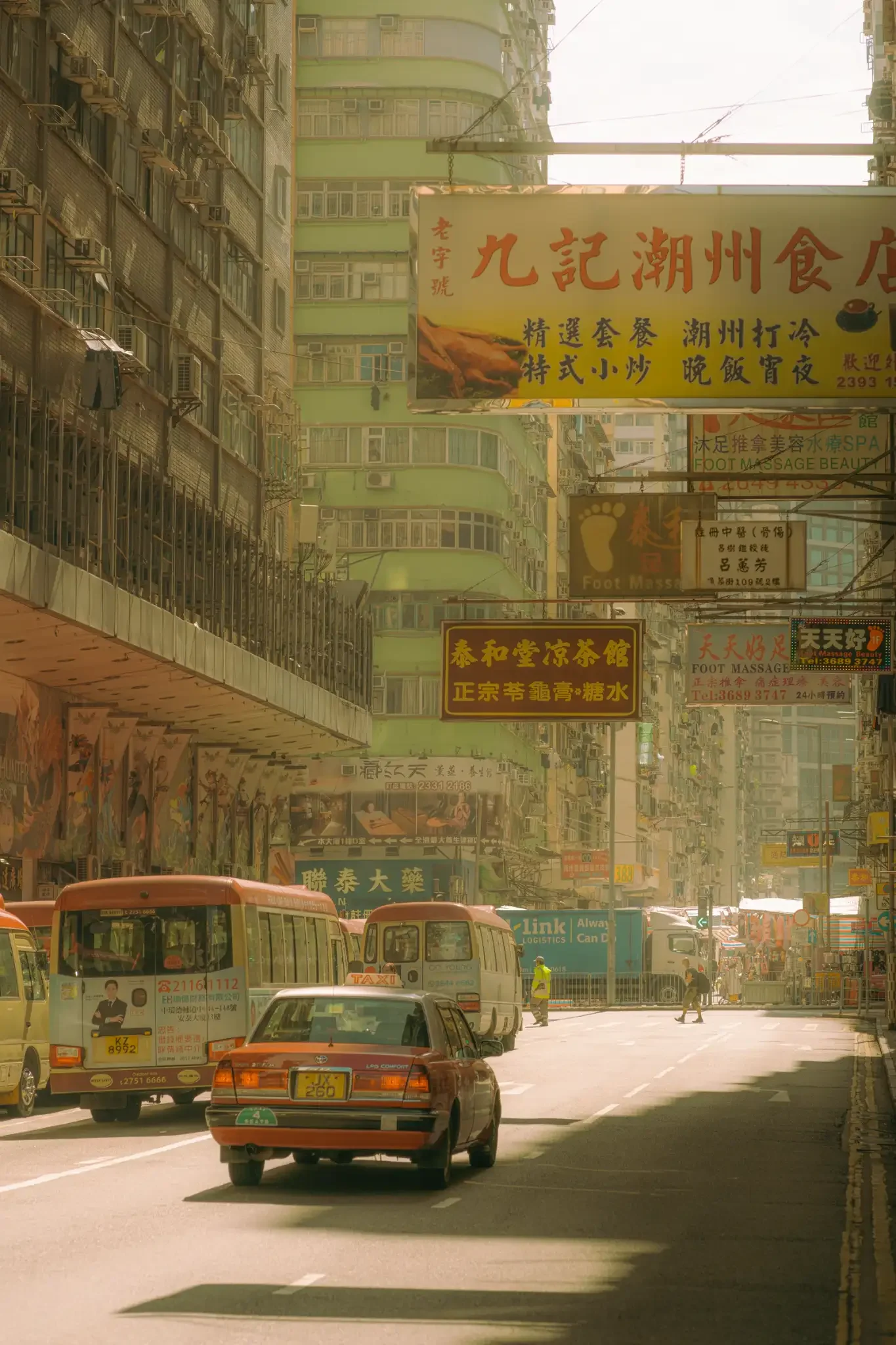 Sun-drenched Hong Kong street photography fine art print. Cinematic urban scene with a red taxi, minibuses, and layered vintage signs. Warm amber wall art decor.