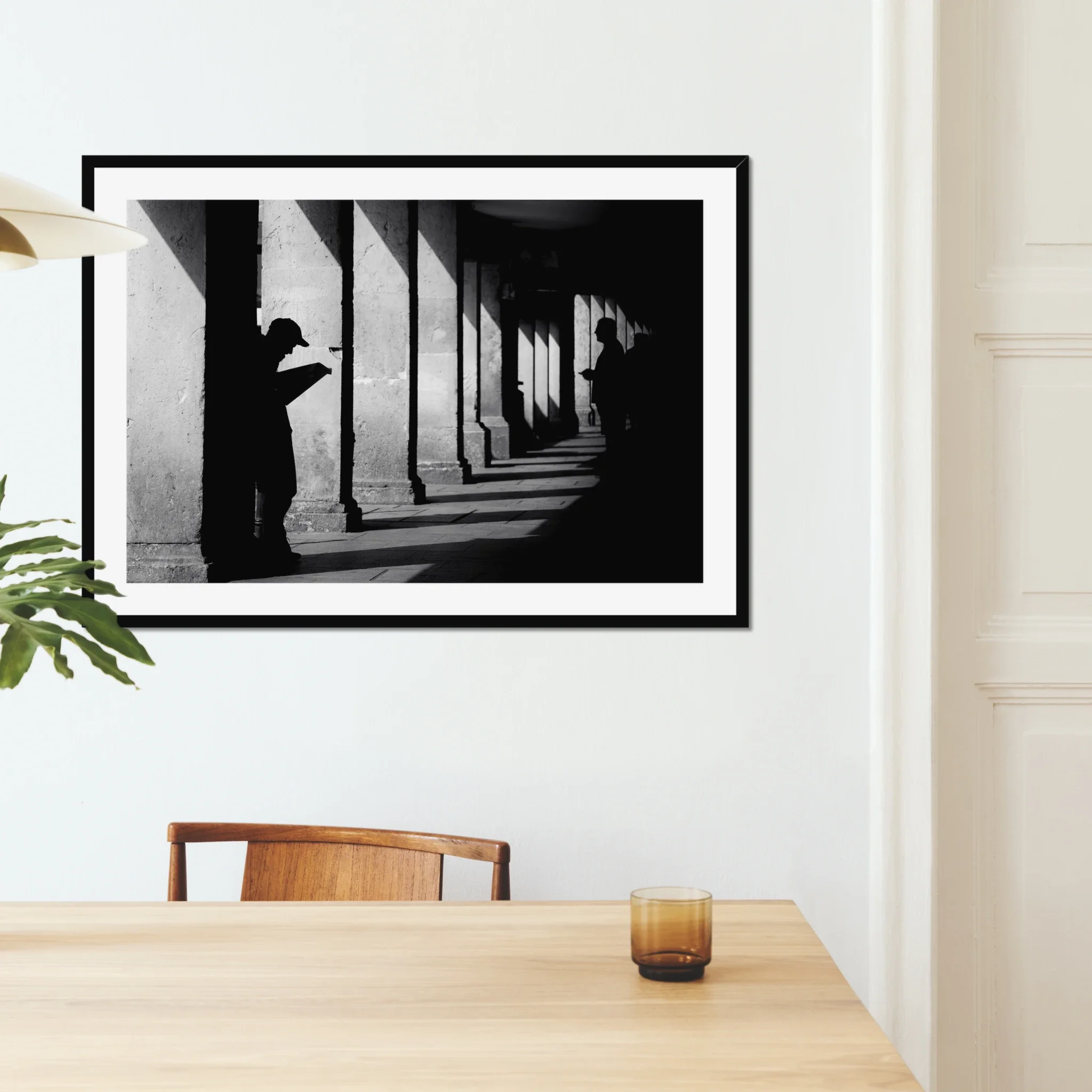 Black and white minimalist street photography print of a lone figure walking up an outdoor staircase. Features strong geometric lines and high-contrast dramatic shadows. Fine art wall decor.
