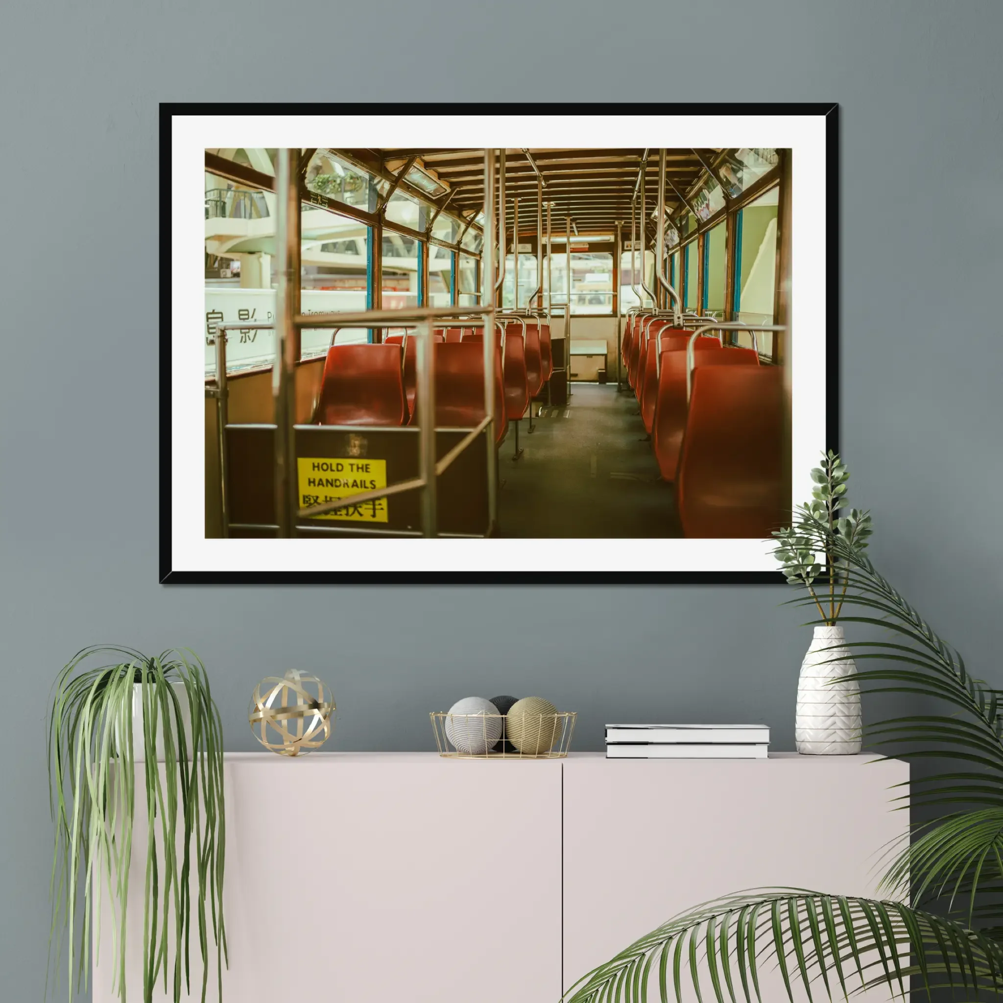 Vintage Hong Kong tram interior fine art print featuring red seats and a hold the handrails sign in warm cinematic tones.