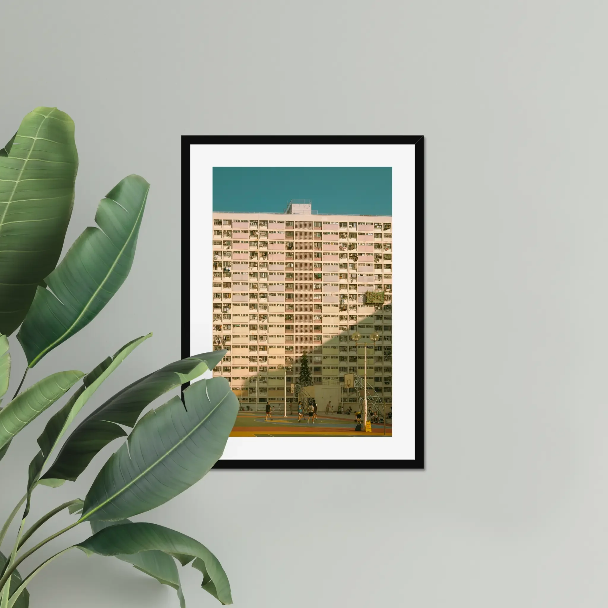 Vintage pastel building of Choi Hung Estate in Hong Kong with a colorful basketball court at golden hour.