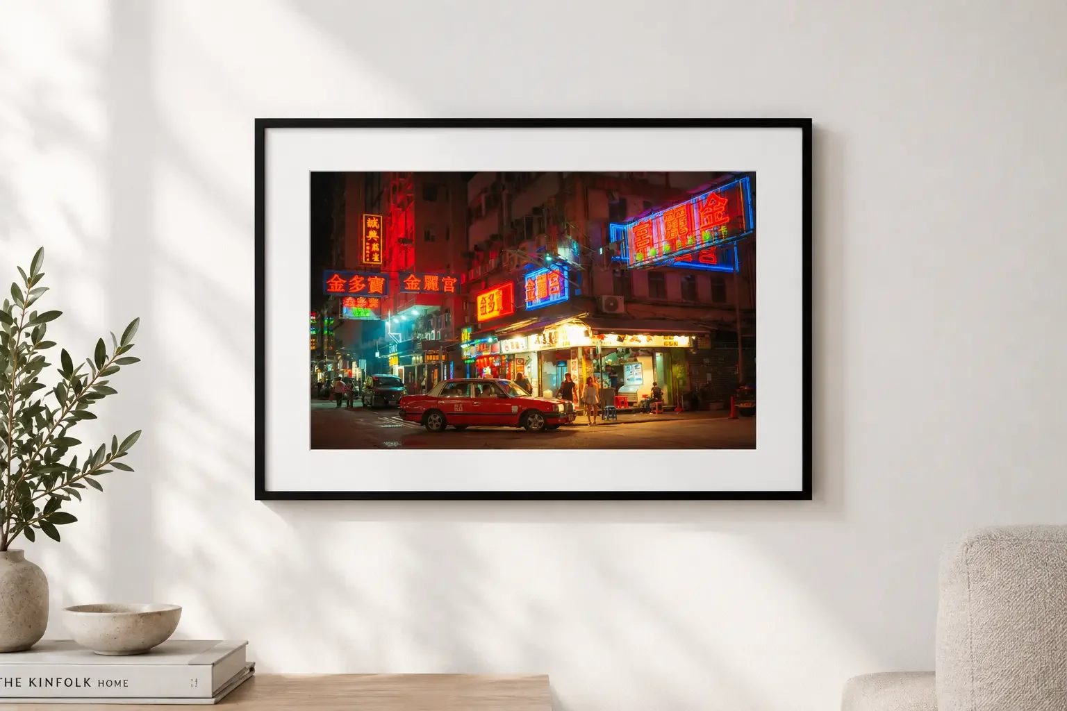 Red Hong Kong taxi parked at a night street corner beneath glowing red, blue and pink neon signs, with a street food stall and pedestrians in the background