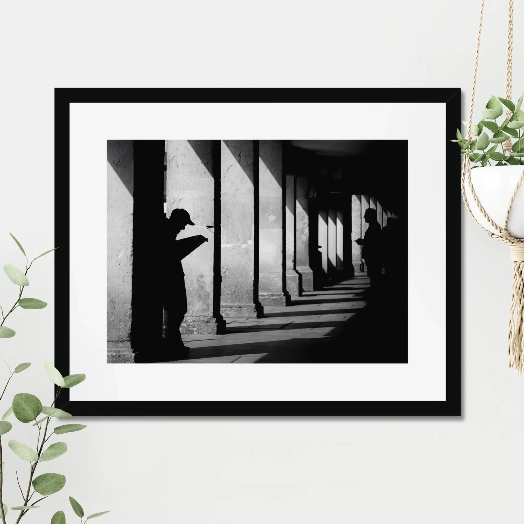 Black and white minimalist street photography print of a lone figure walking up an outdoor staircase. Features strong geometric lines and high-contrast dramatic shadows. Fine art wall decor.