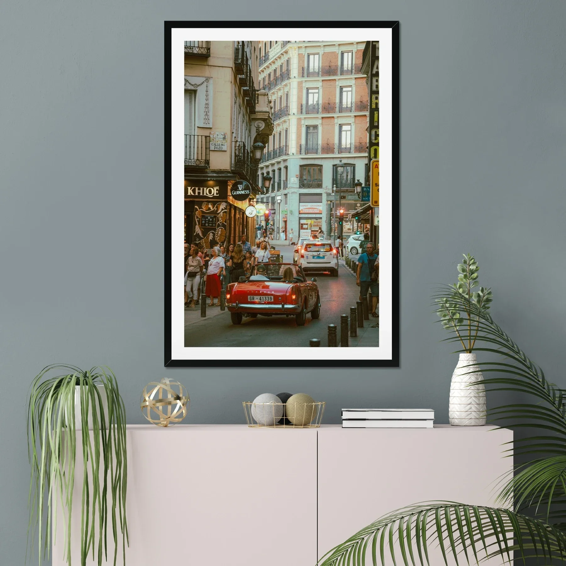 Classic red Sunbeam Alpine vintage car driving through Madrid streets at sunset, golden hour lighting, Lomography X-Pro film style photography, retro Spanish urban scene.