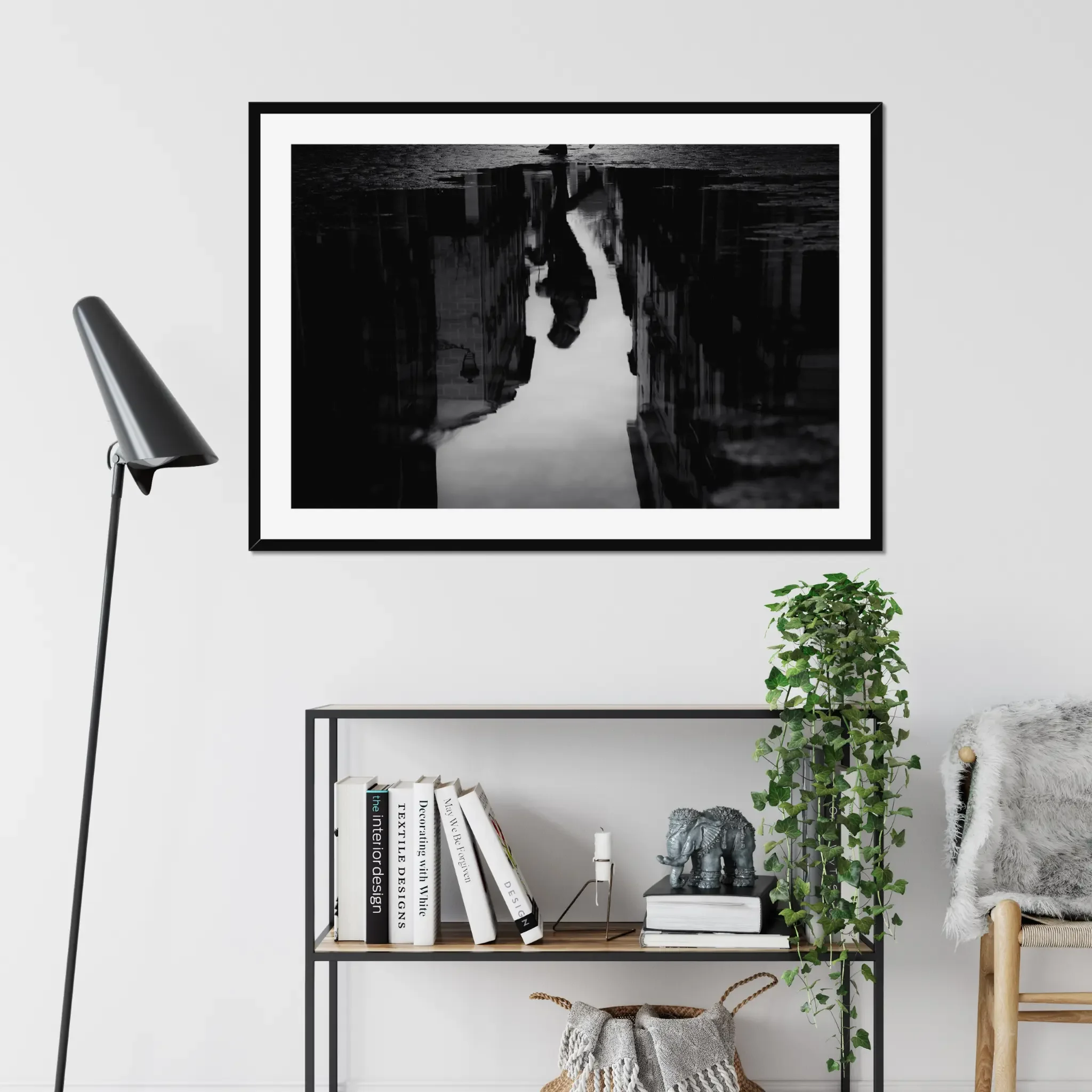 Black and white moody street photography print of a person with an umbrella walking in the rain. Features a striking reflection on wet pavement. Cinematic fine art wall decor.