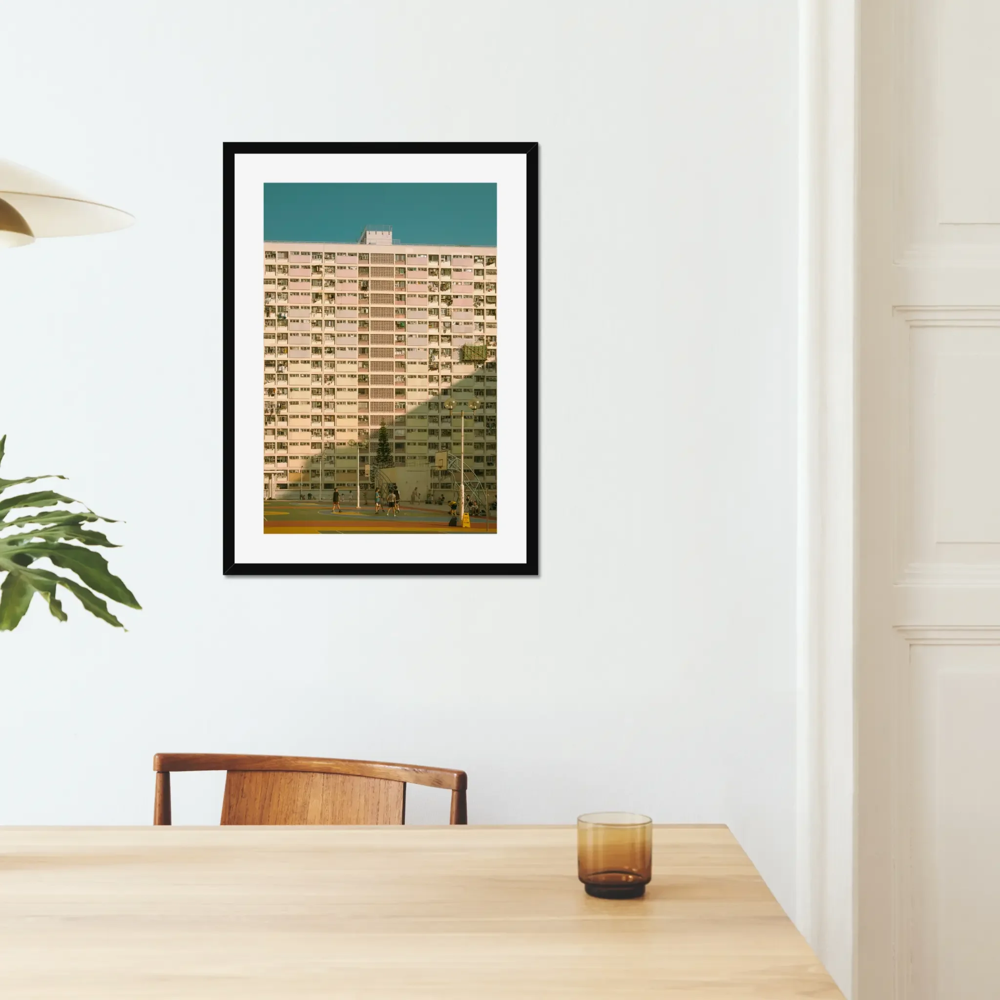 Vintage pastel building of Choi Hung Estate in Hong Kong with a colorful basketball court at golden hour.