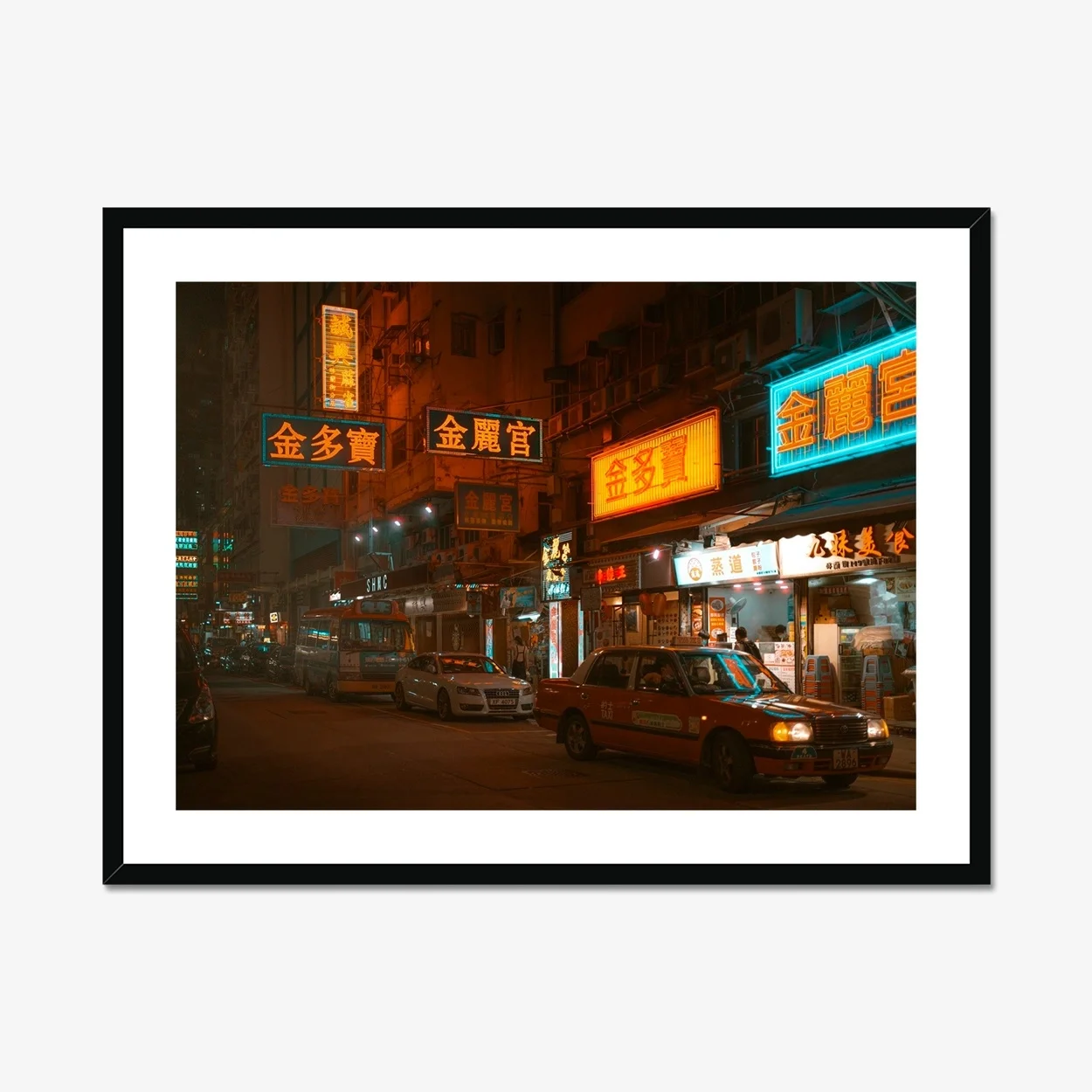 Night street photography of a red taxi in Mongkok, Hong Kong, surrounded by vibrant glowing neon signs and city lights.