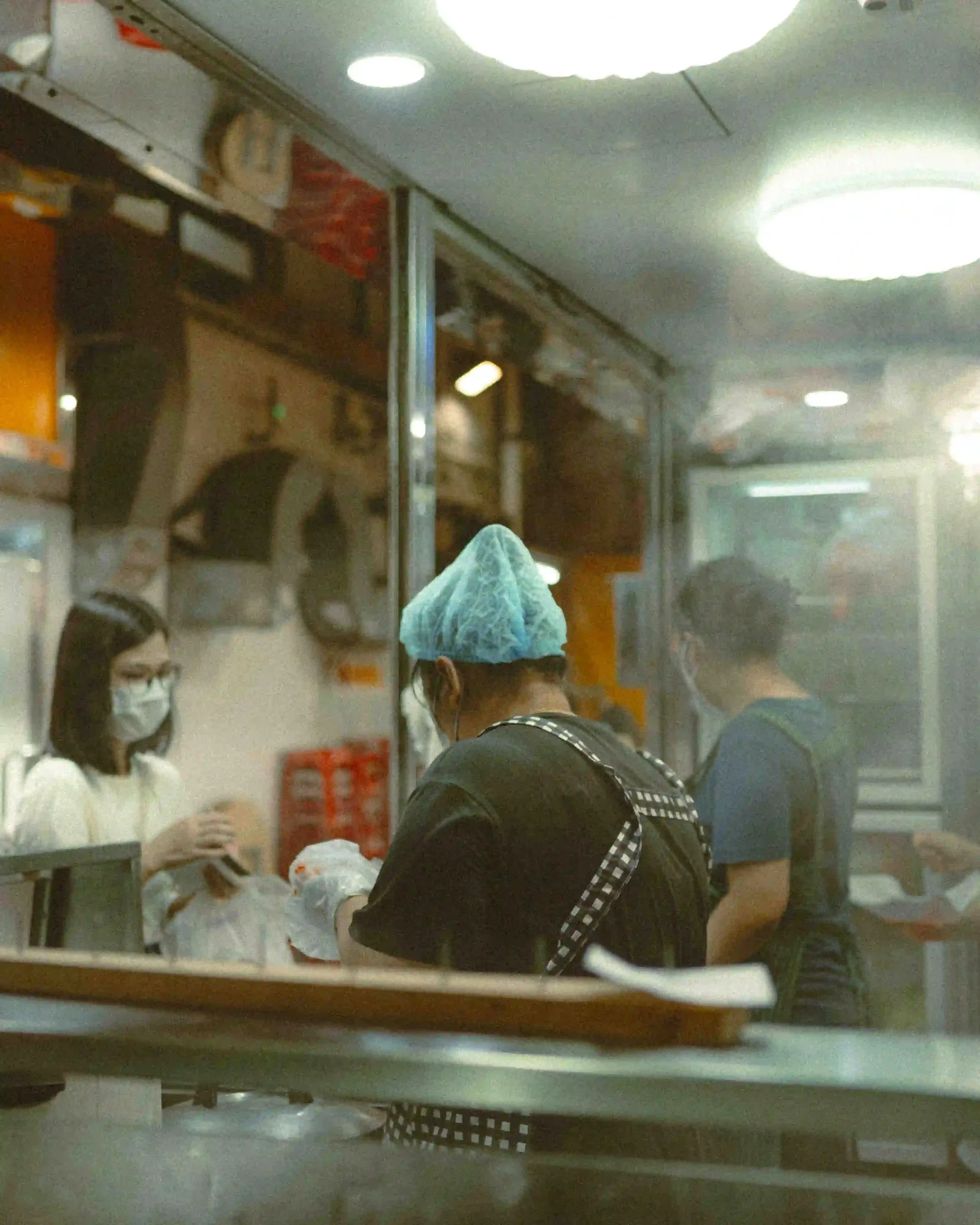 Before and after comparison using Lomography 800 Lightroom preset on a night street photography scene with vibrant neon lights and film grain.