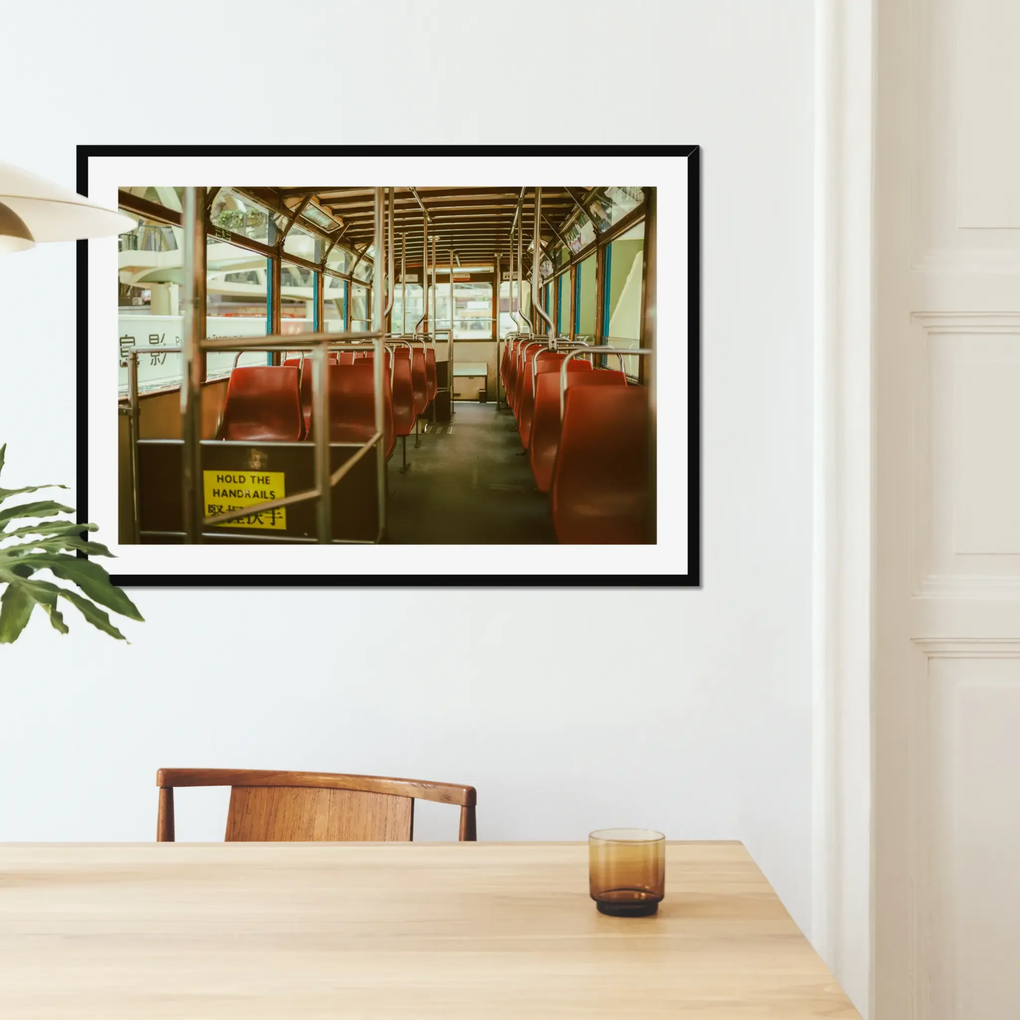 Vintage Hong Kong tram interior fine art print featuring red seats and a hold the handrails sign in warm cinematic tones.