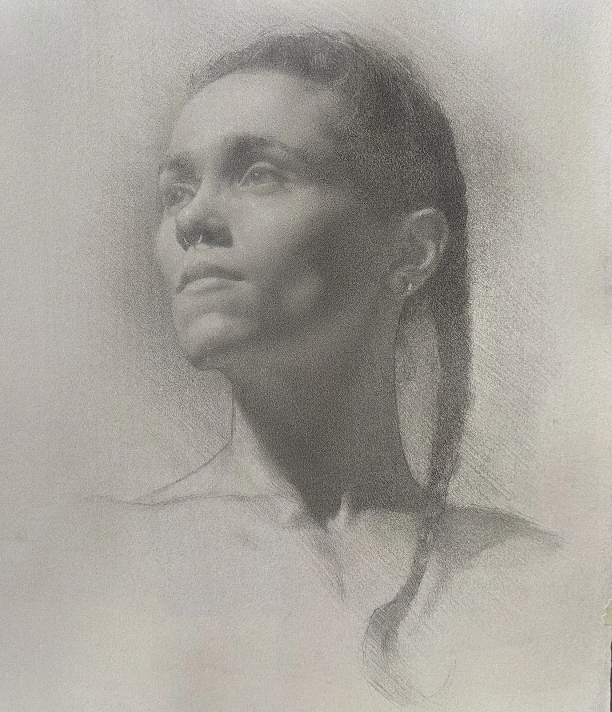 A realistic pencil sketch of a young woman with her hair in a braid, wearing a necklace, looking slightly upward and to the side.