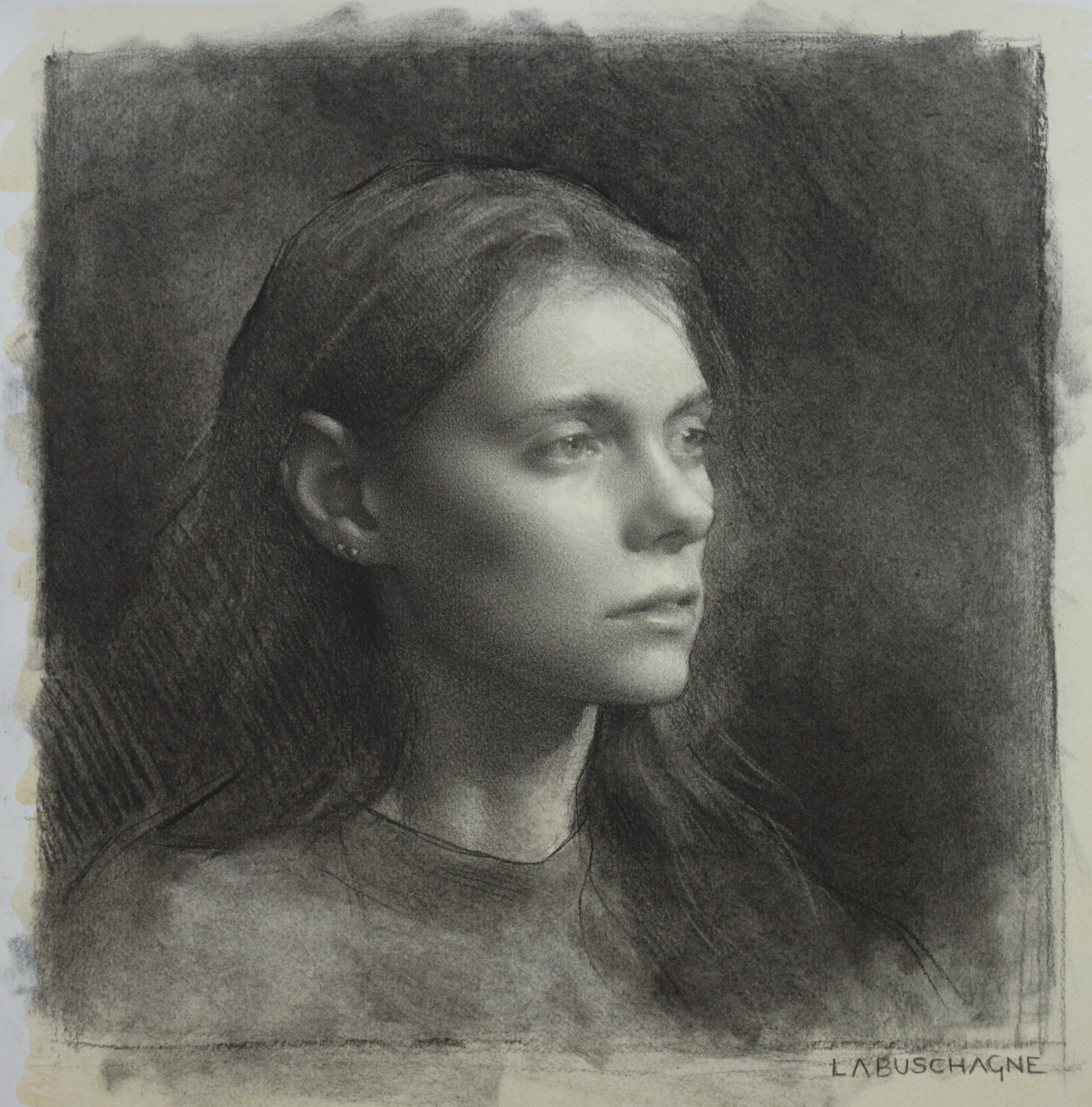 A detailed graphite pencil portrait of a young woman with long hair, gazing thoughtfully to the side, with soft shading and realistic features, signed by La Bushagne.