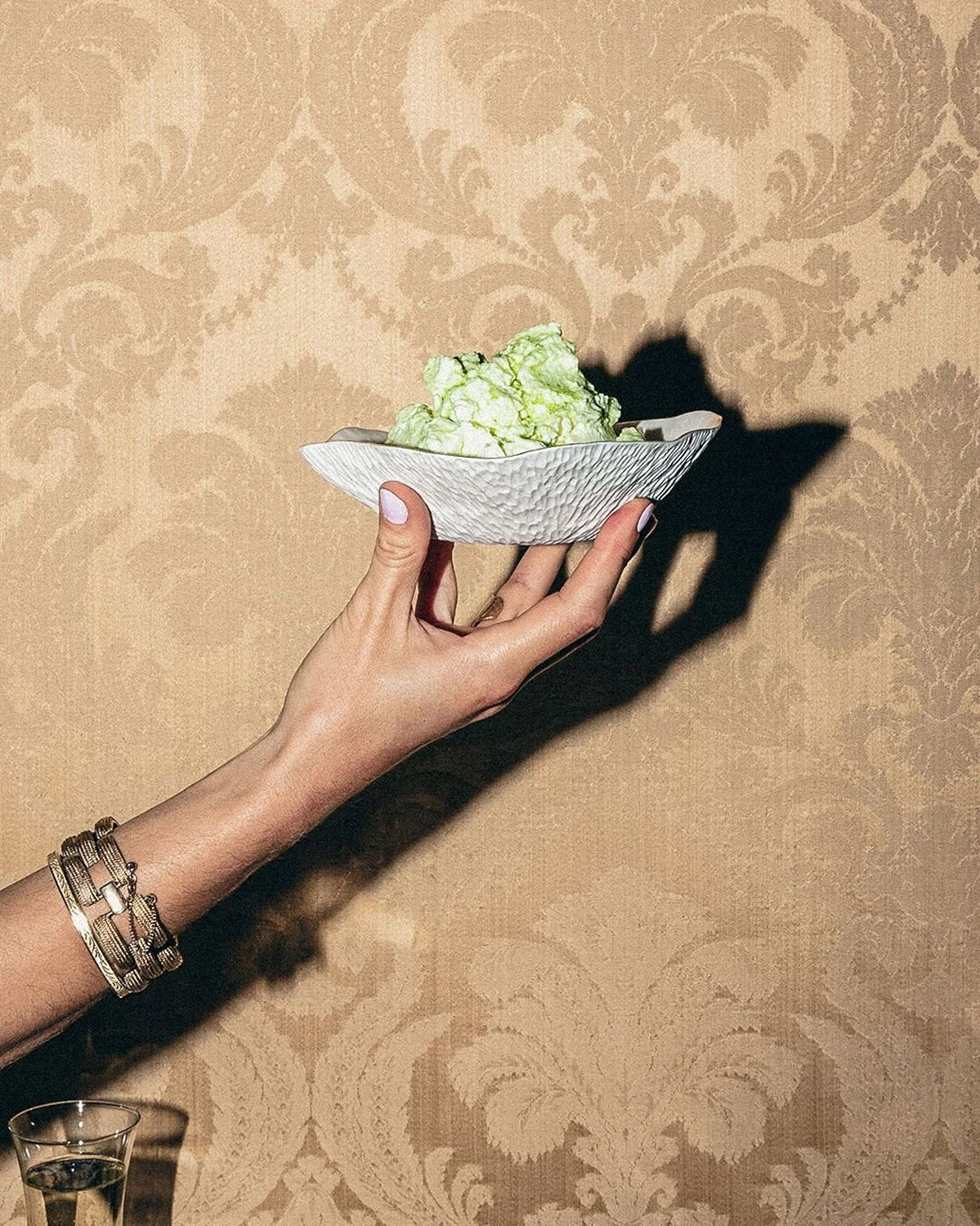 Hand holding a white Indulge bowl of green ice cream, Sarah-Linda, sensual tableware, branding, web design and editorial project by Automne Studio.