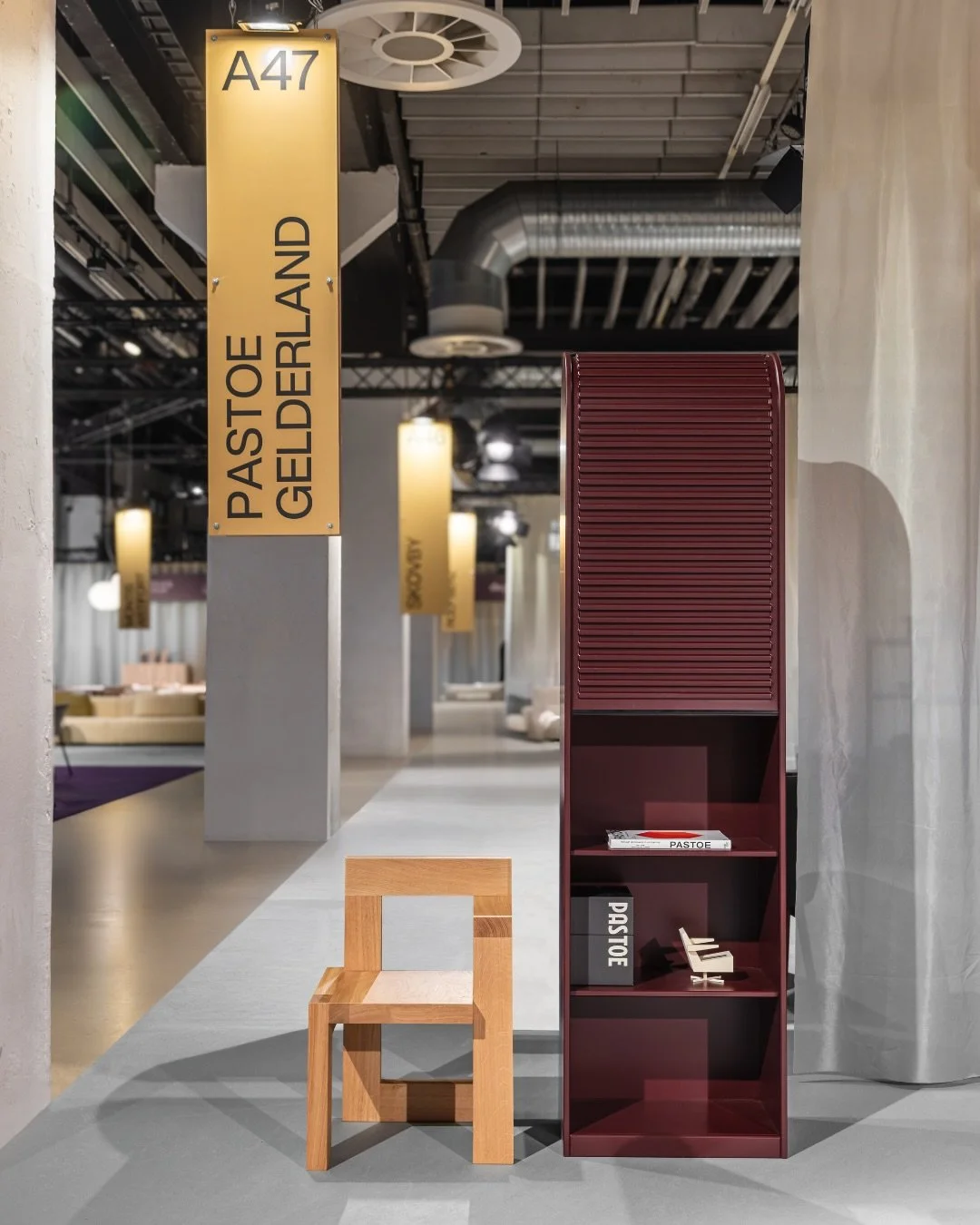 Interior design showroom with a yellow “PASTOE” sign, timeless dutch furniture design, branding project by Automne Studio.