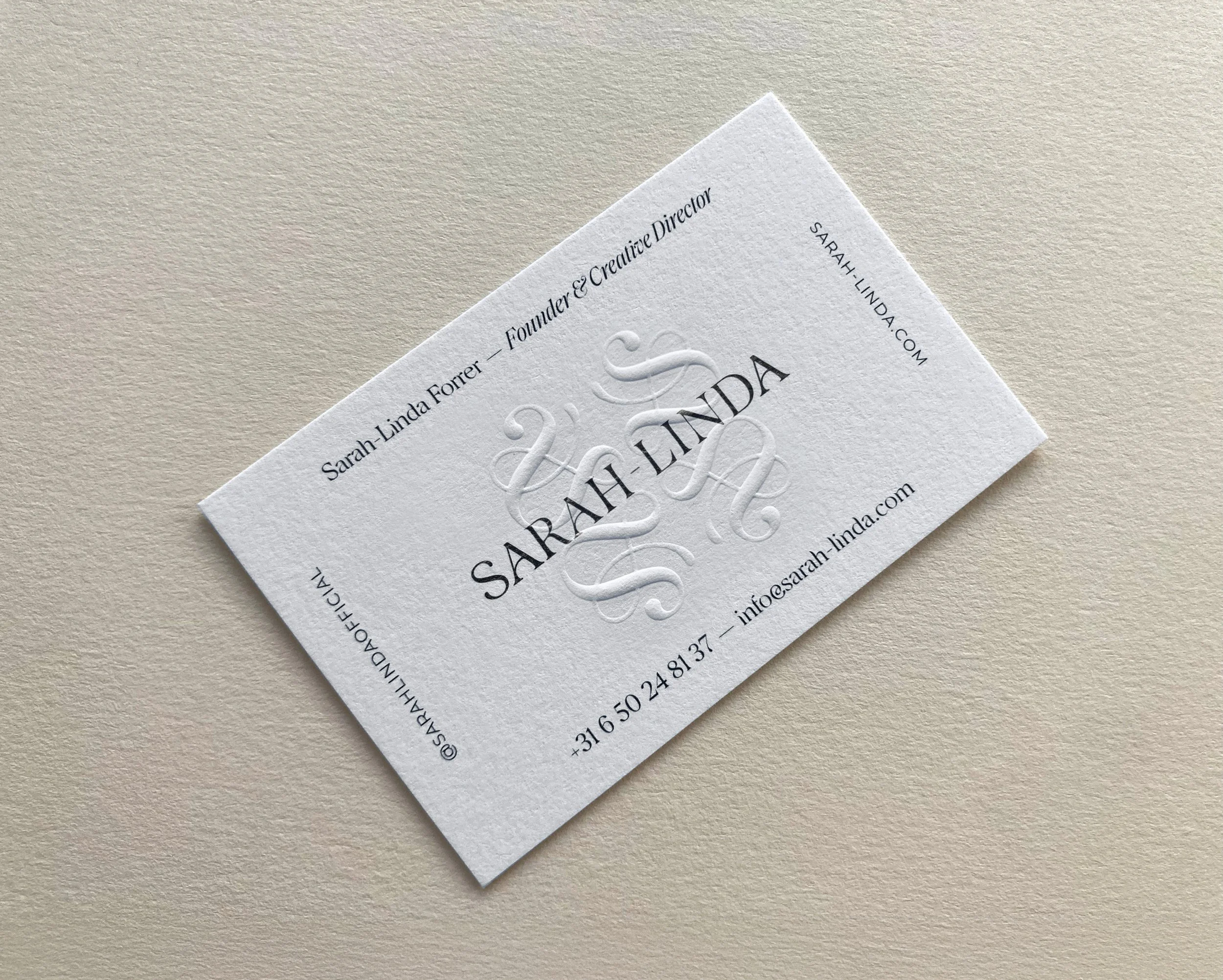 White Sarah-Linda business card with embossed logo, sensual tableware, branding, web design and editorial project by Automne Studio.