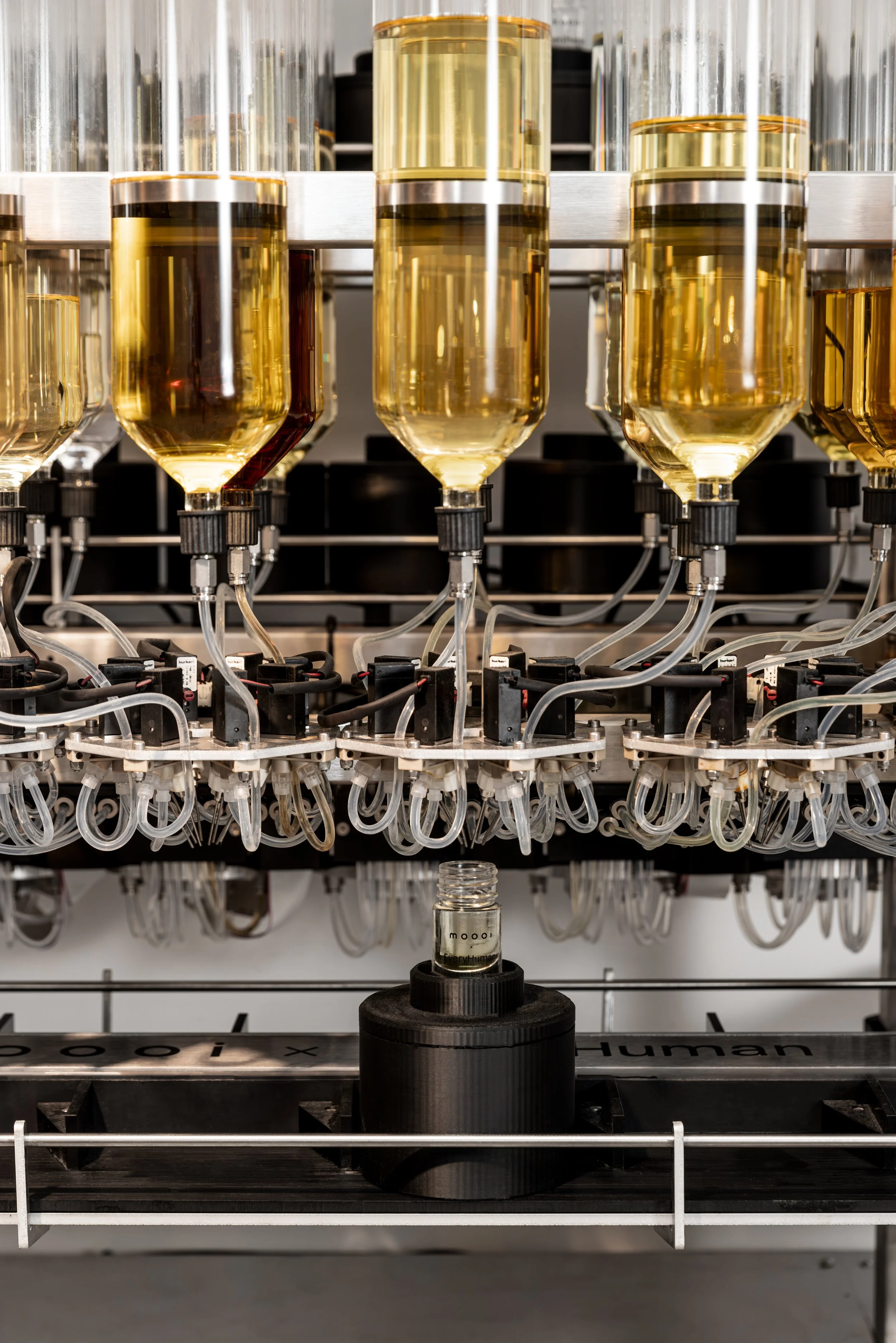 Moooi x EveryHuman fragrance bottle connected by tubing and dispensing mechanisms, packaging and branding project by Automne Studio.