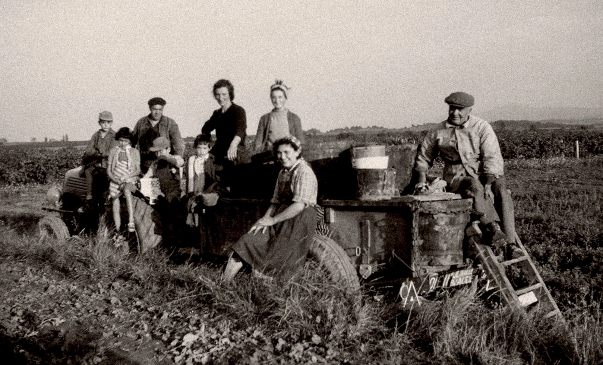 Black-and-white old photograph of the Guilhem family posing with farm equipment in a vine, Maison Guilhem, French vineyard, branding and editorial project by Automne Studio.