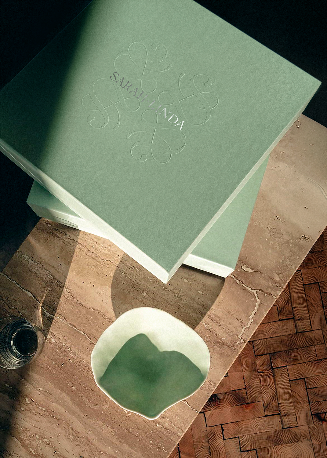 Green Sarah-Linda tableware box embossed with “Sarah Linda” beside a green Indulge bowl, sensual tableware, branding, web design and editorial project by Automne Studio.