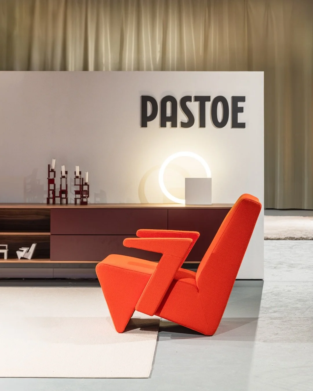 Bright orange modern lounge chair in a contemporary living room, Pastoe, timeless dutch furniture design, branding project by Automne Studio.