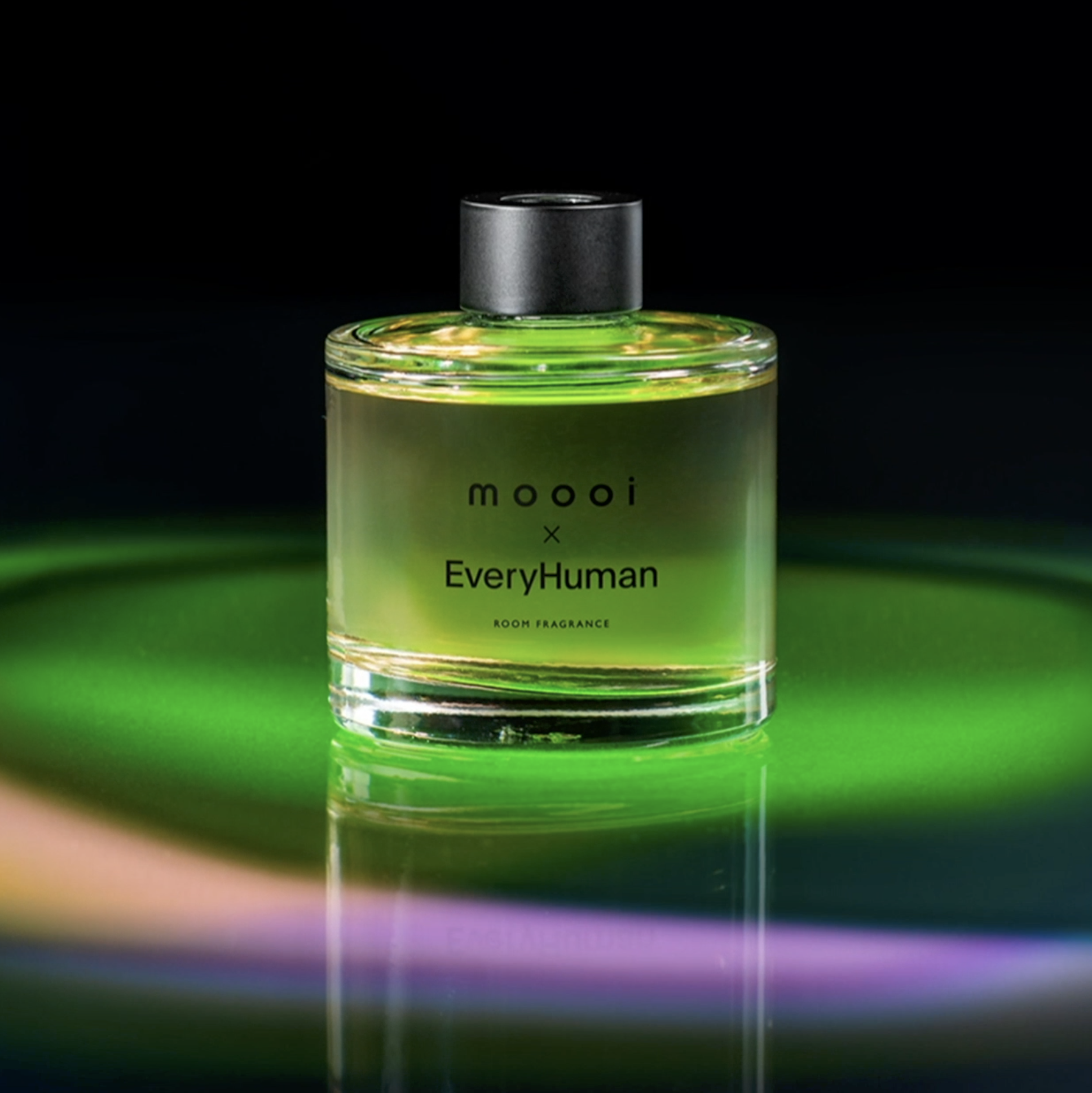 Mooooi x EveryHuman fragrance bottle with black cap against a neon-lit background, branding project by Automne Studio.