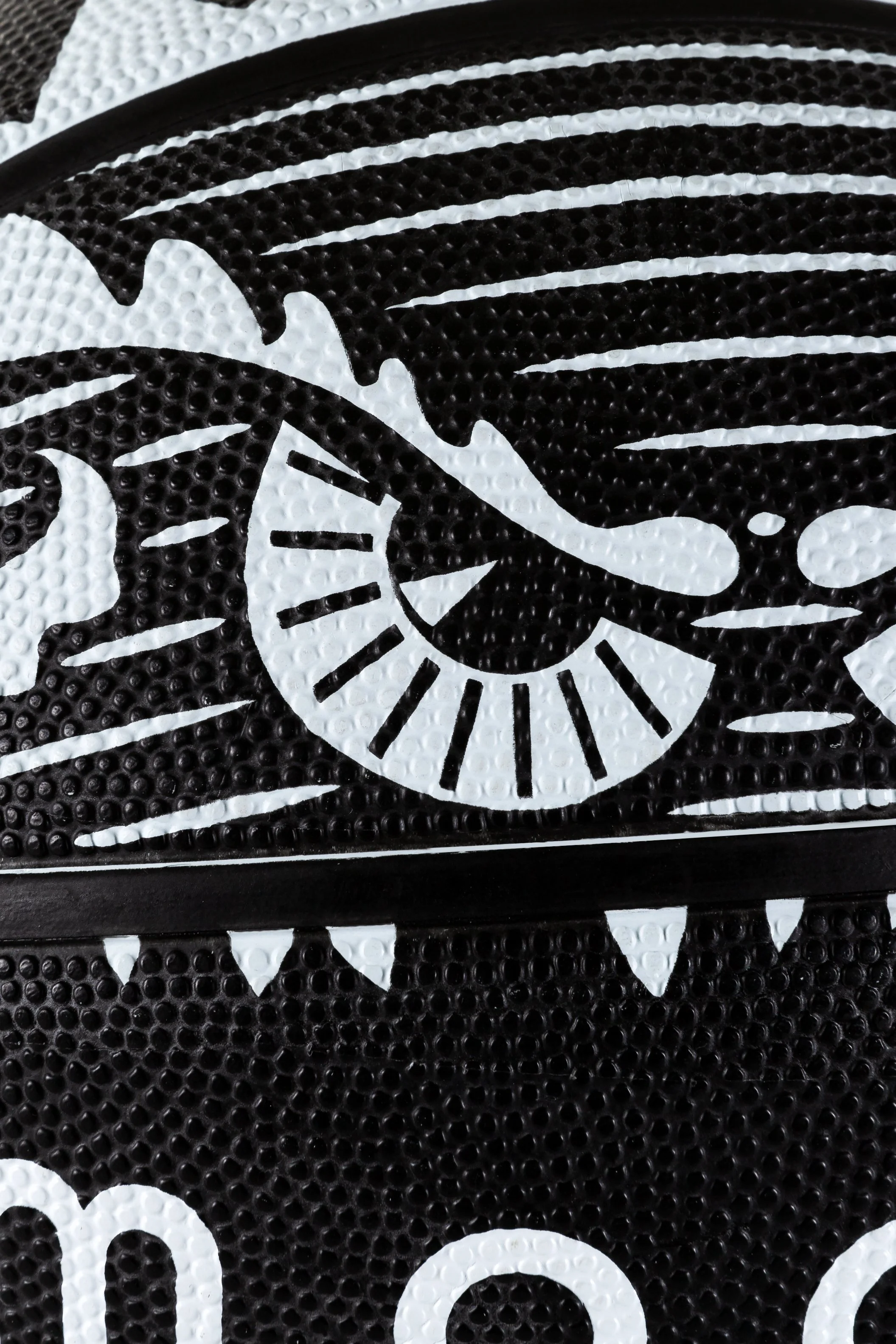 Close-up of a black-and-white Moooi x Spalding basketball, with the Marcel Wanders’ iconic Monster graphics, illustration project by Automne Studio.