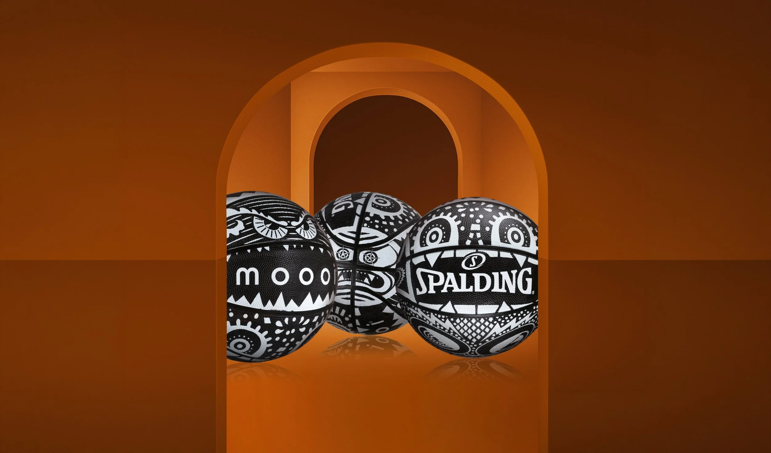 Three black-and-white Moooi x Spalding basketballs displayed against an orange arched backdrop, with the Marcel Wanders’ iconic Monster graphics, illustration project by Automne Studio.