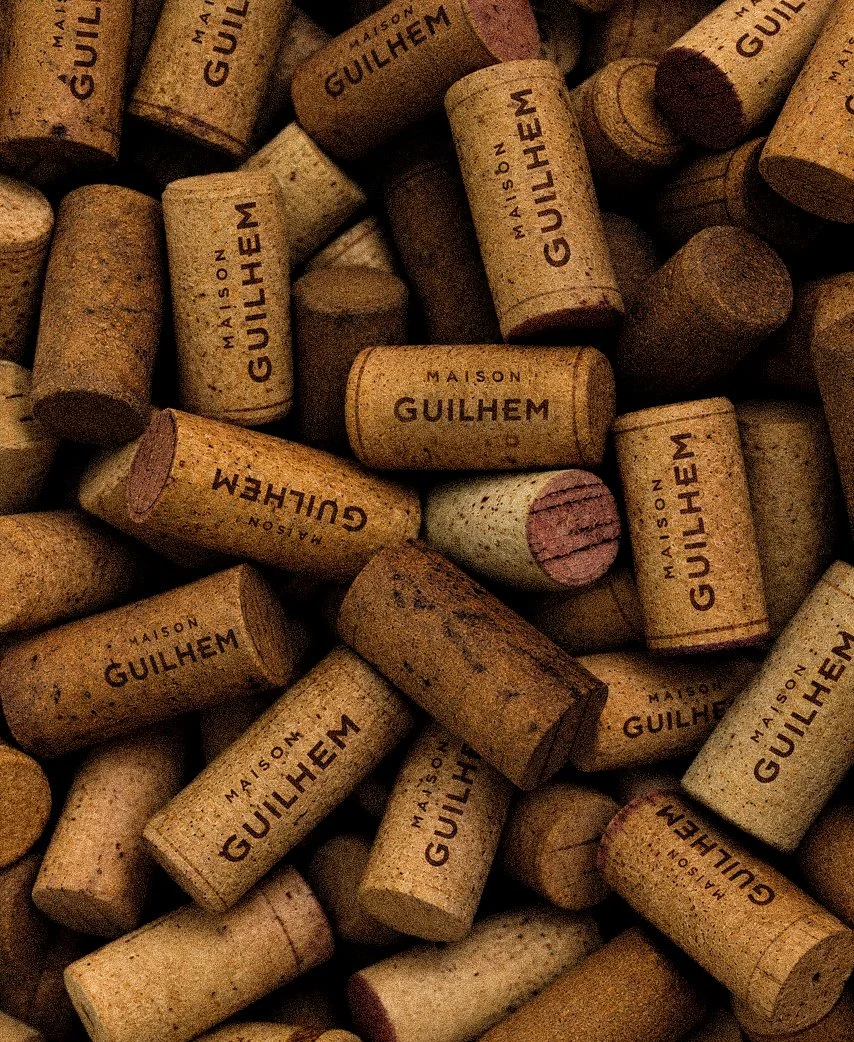 Close-up of wine corks stamped Maison Guilhem, French vineyard, branding and editorial project by Automne Studio.
