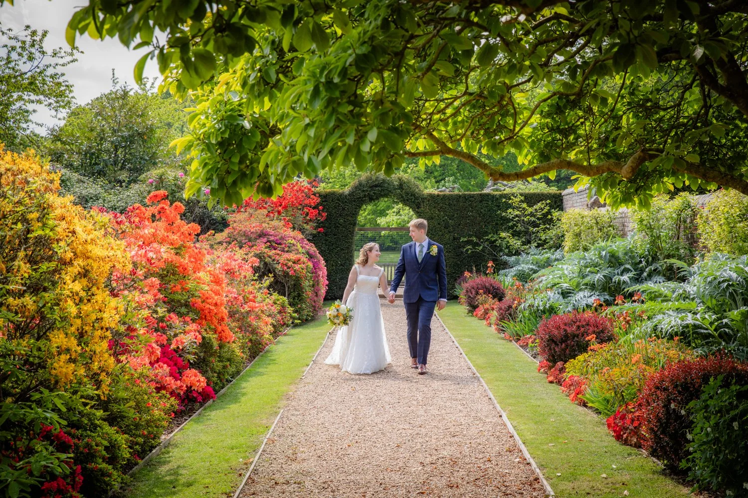 Bride and Groom walking through castle gardens in East Sussex.
