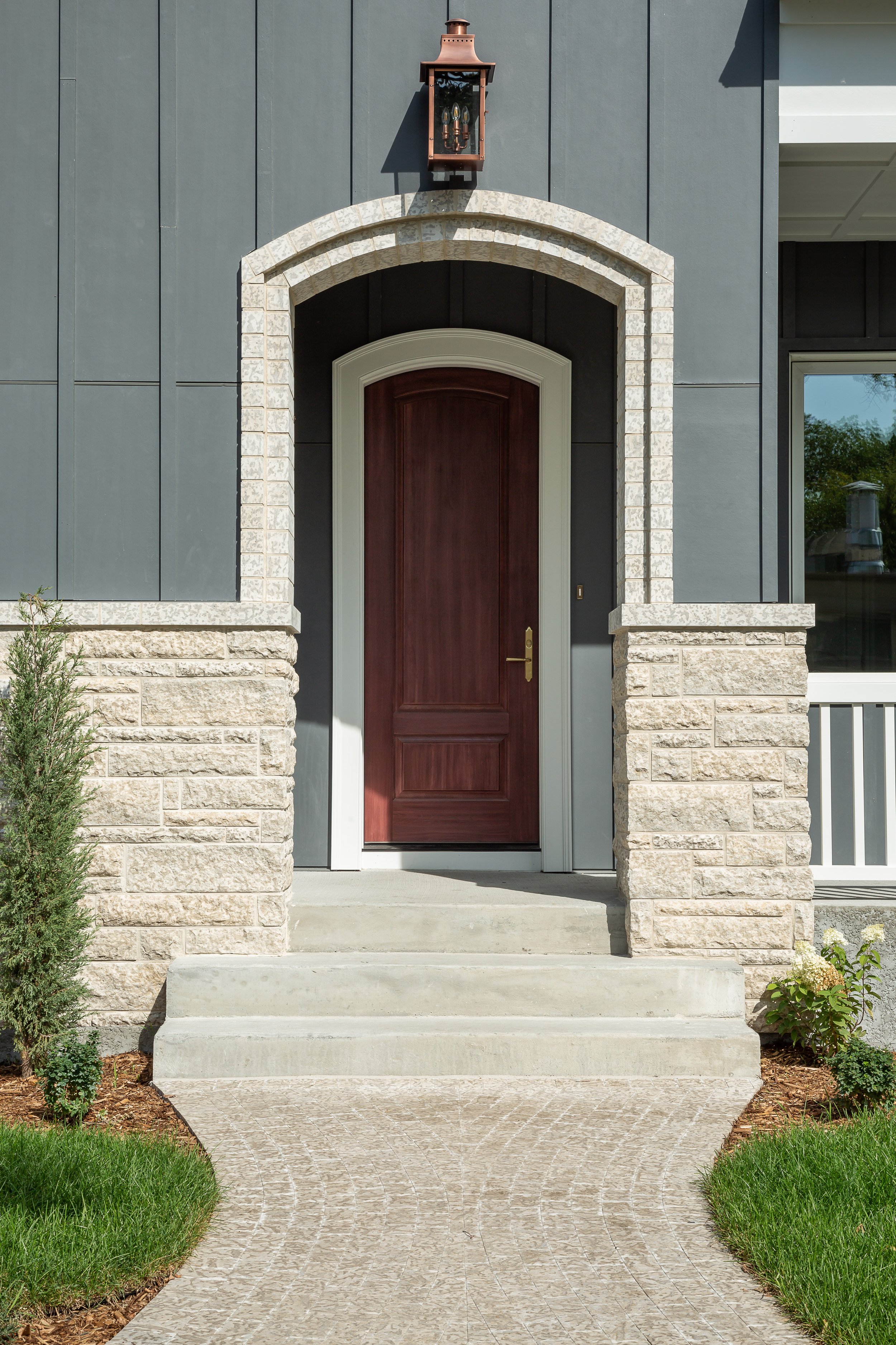 Wood Front door with limestone front entryway and front porch