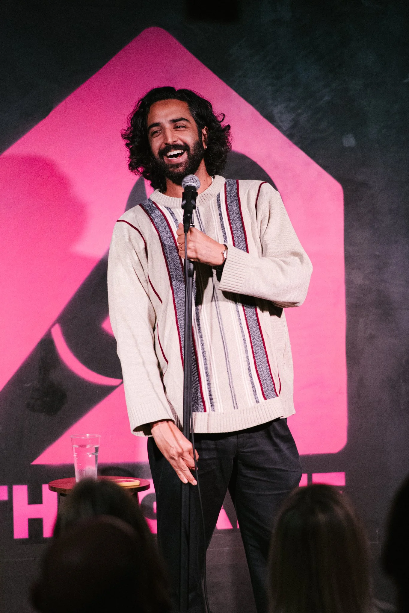 Comedian Rajiv Karia performing onstage at The Gaffe Comedy Club