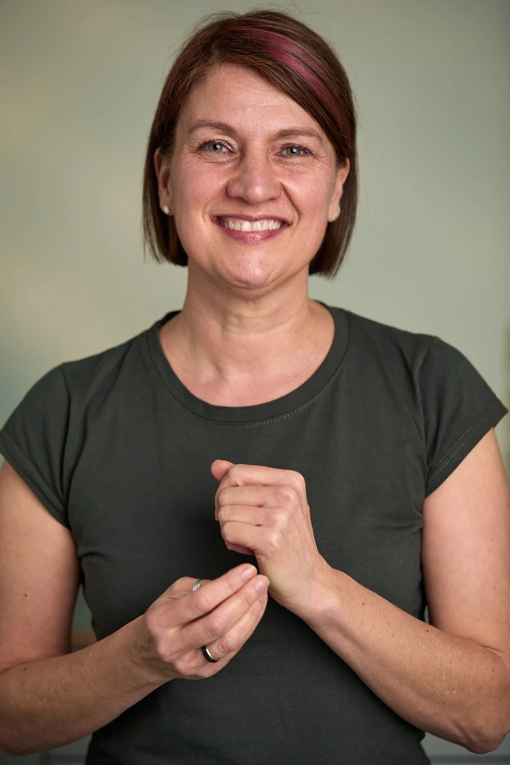Caroline tapping on the side of her hand, smiling to camera