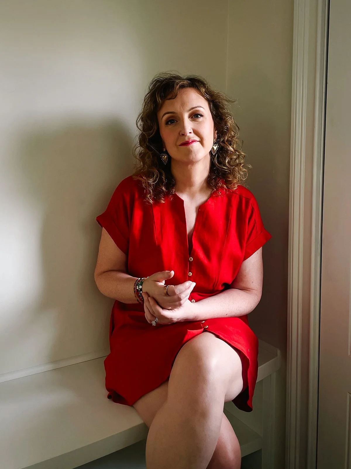 moyra-sitting-looking-at-camera-red-dress.jpg