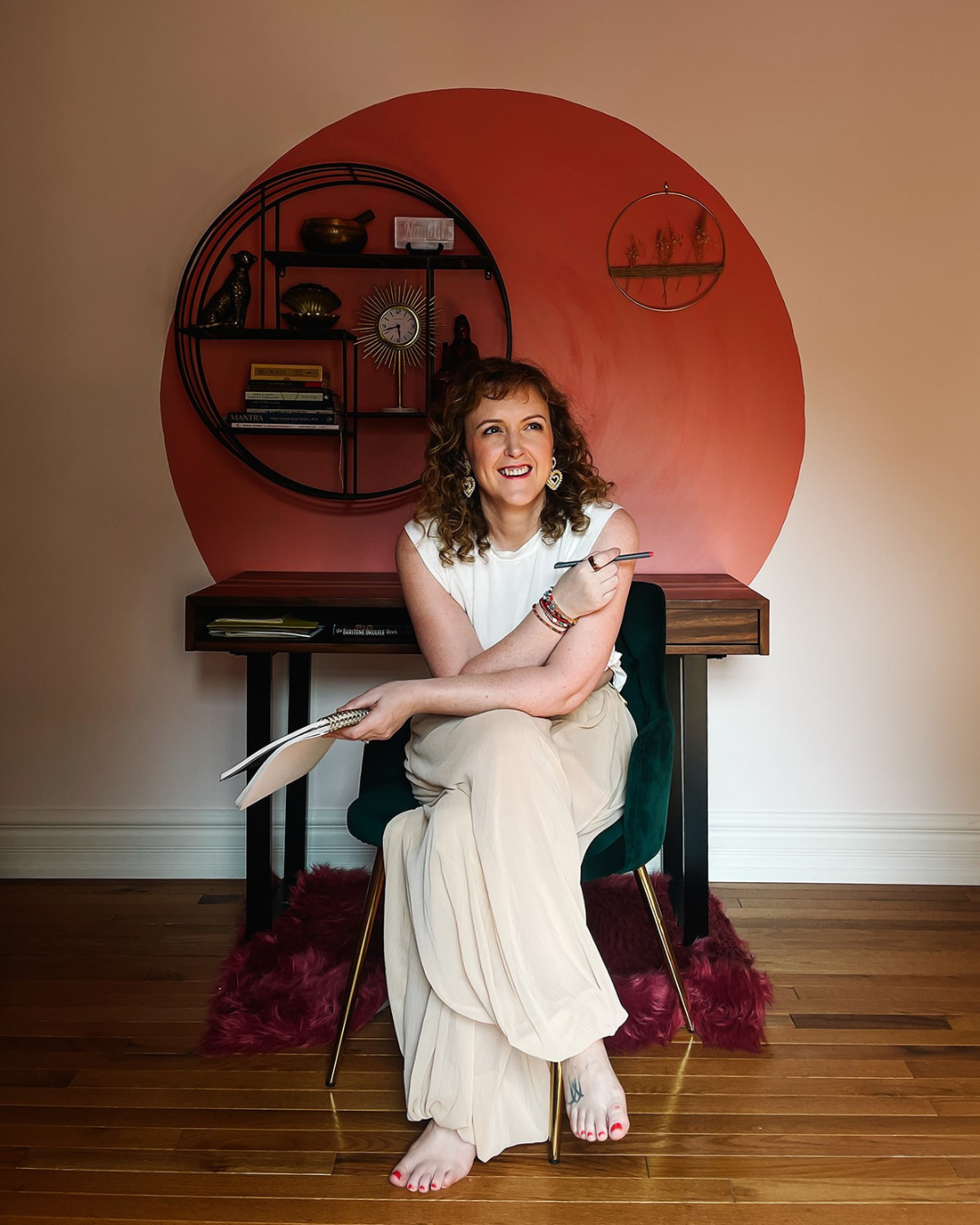 moyra-michelle-hypnotherapy-healing-sitting-smiling-with-notebook.png