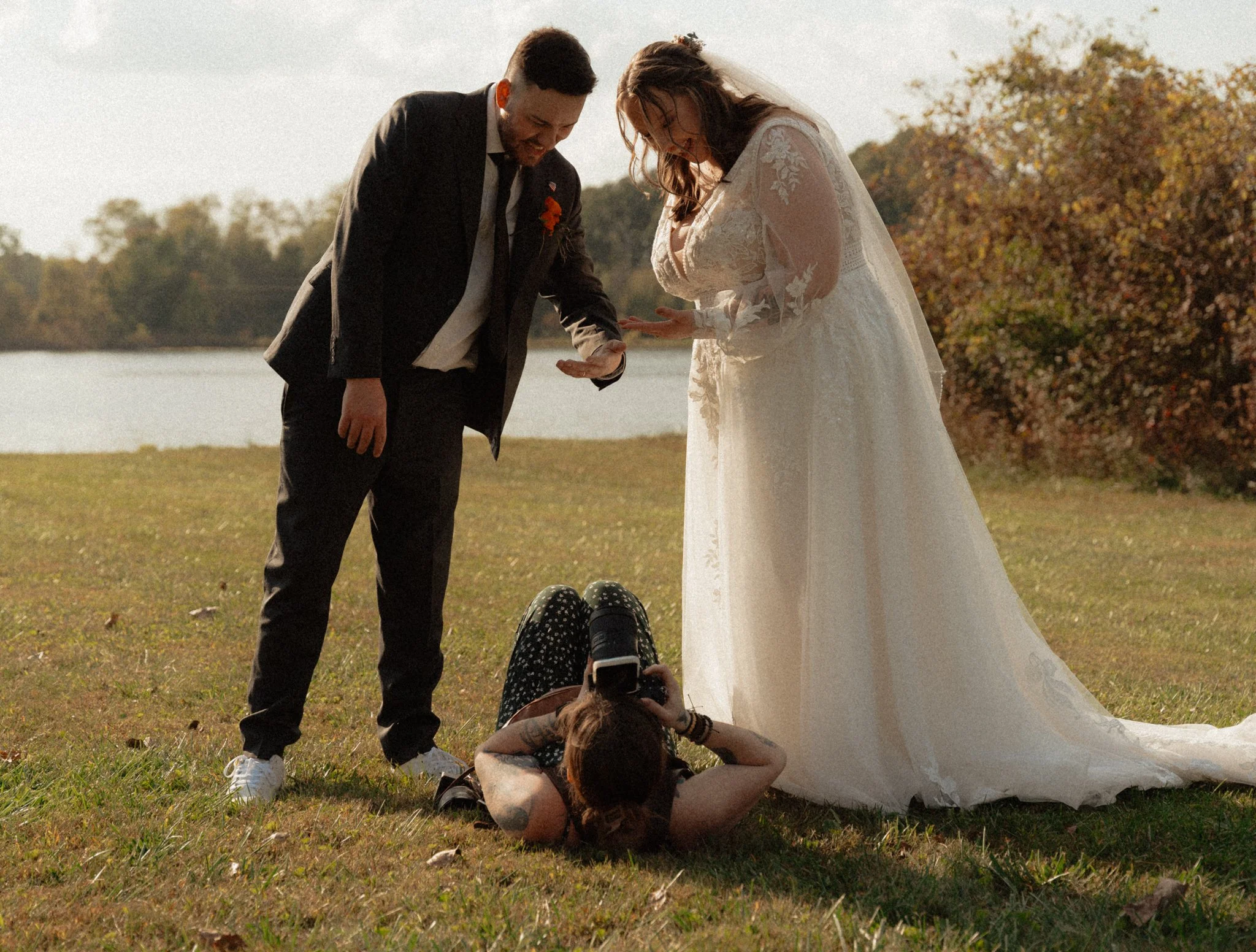 Photographer laying on the ground getting a photo of the bride and groom
