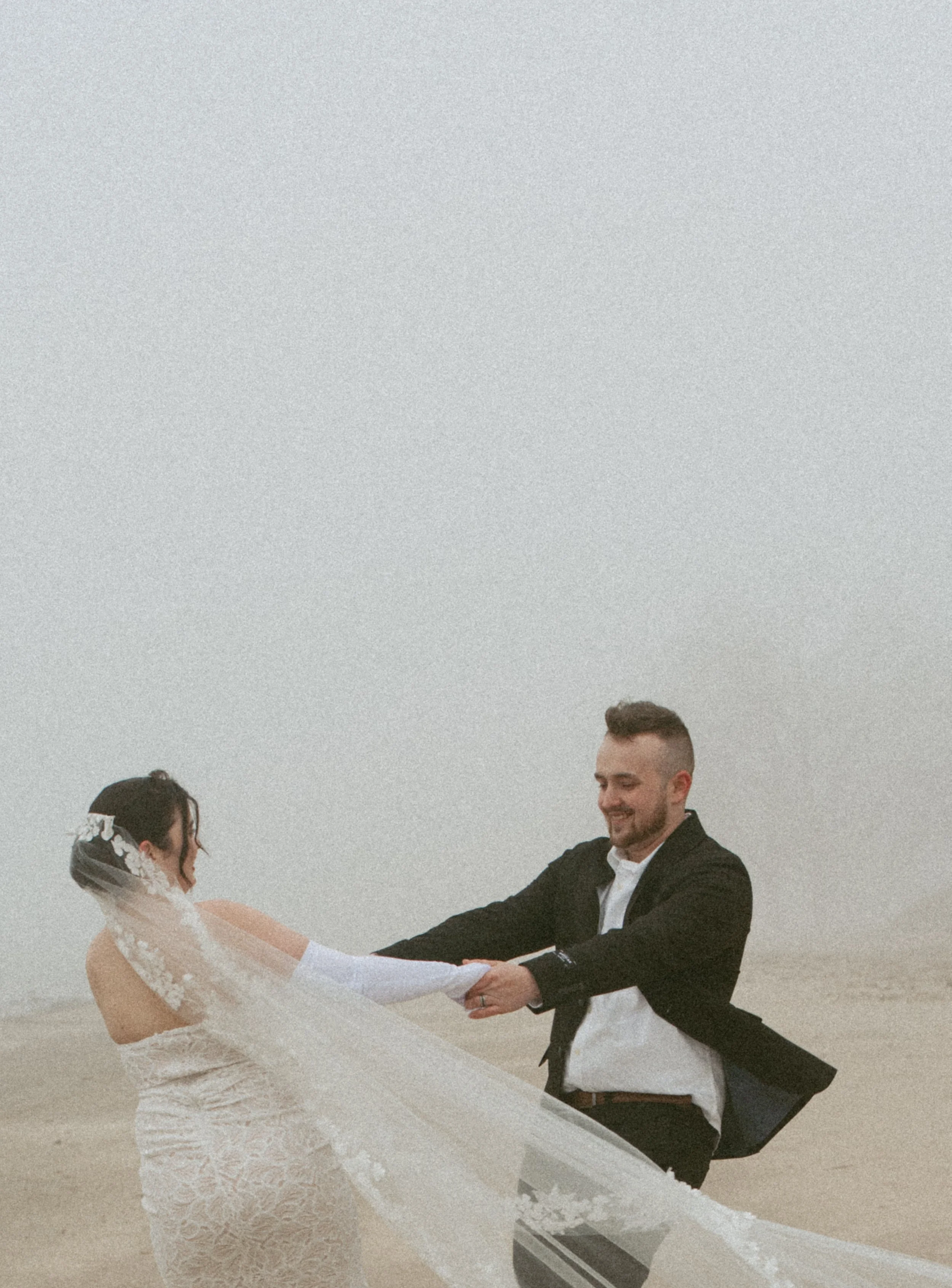 Bride and groom spinning around together on the beach at Sterling State Park Monroe Mi.