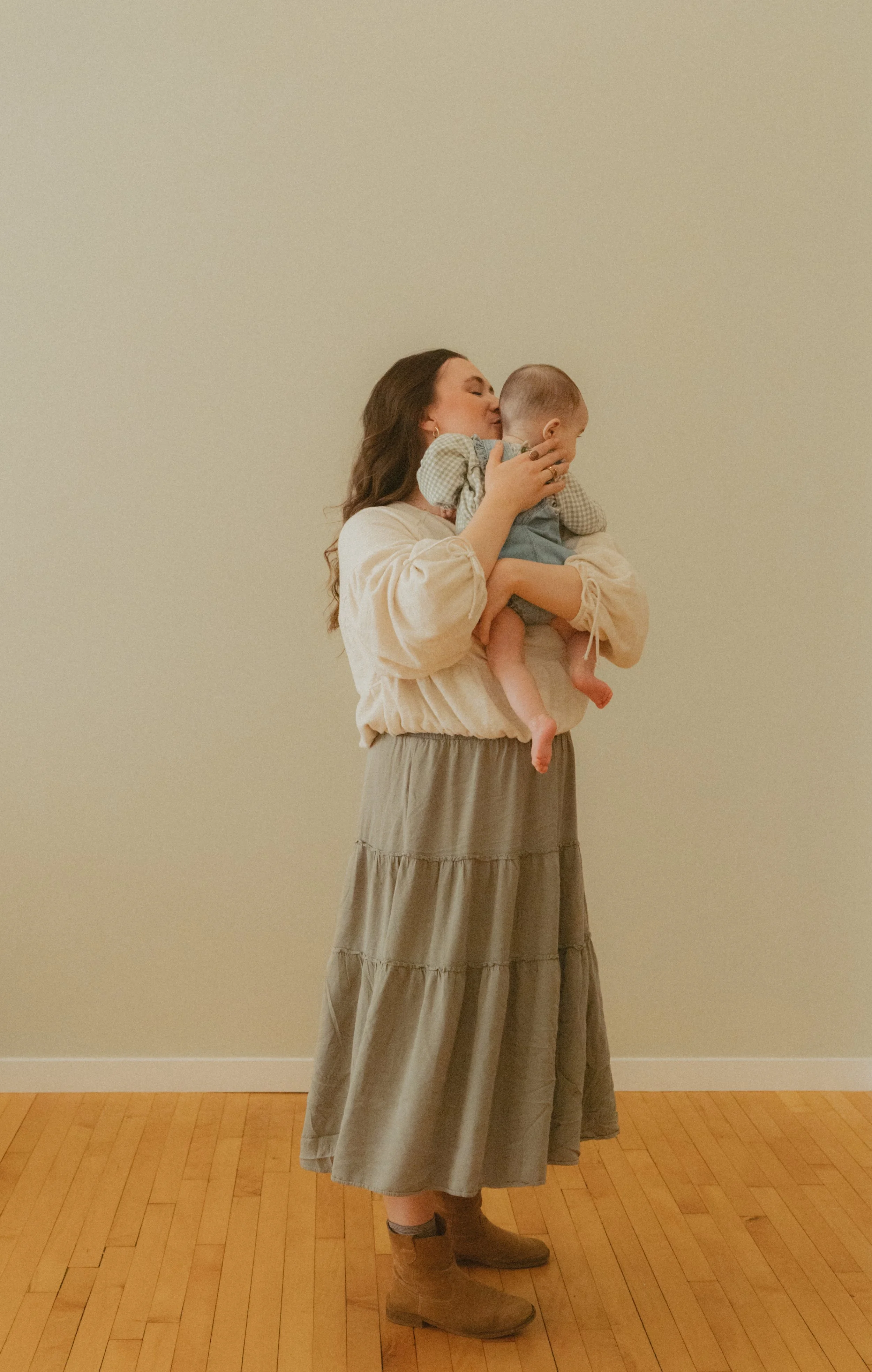 Mother holding baby and kissing her head.