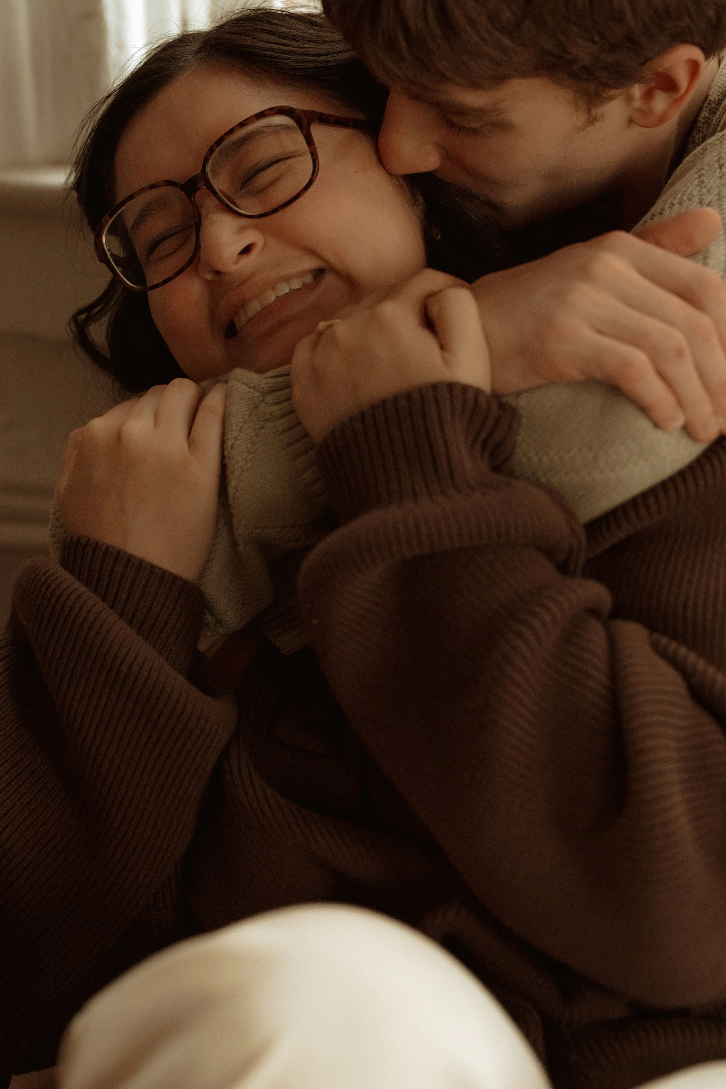 Future bride getting hugged from behind by future husband.