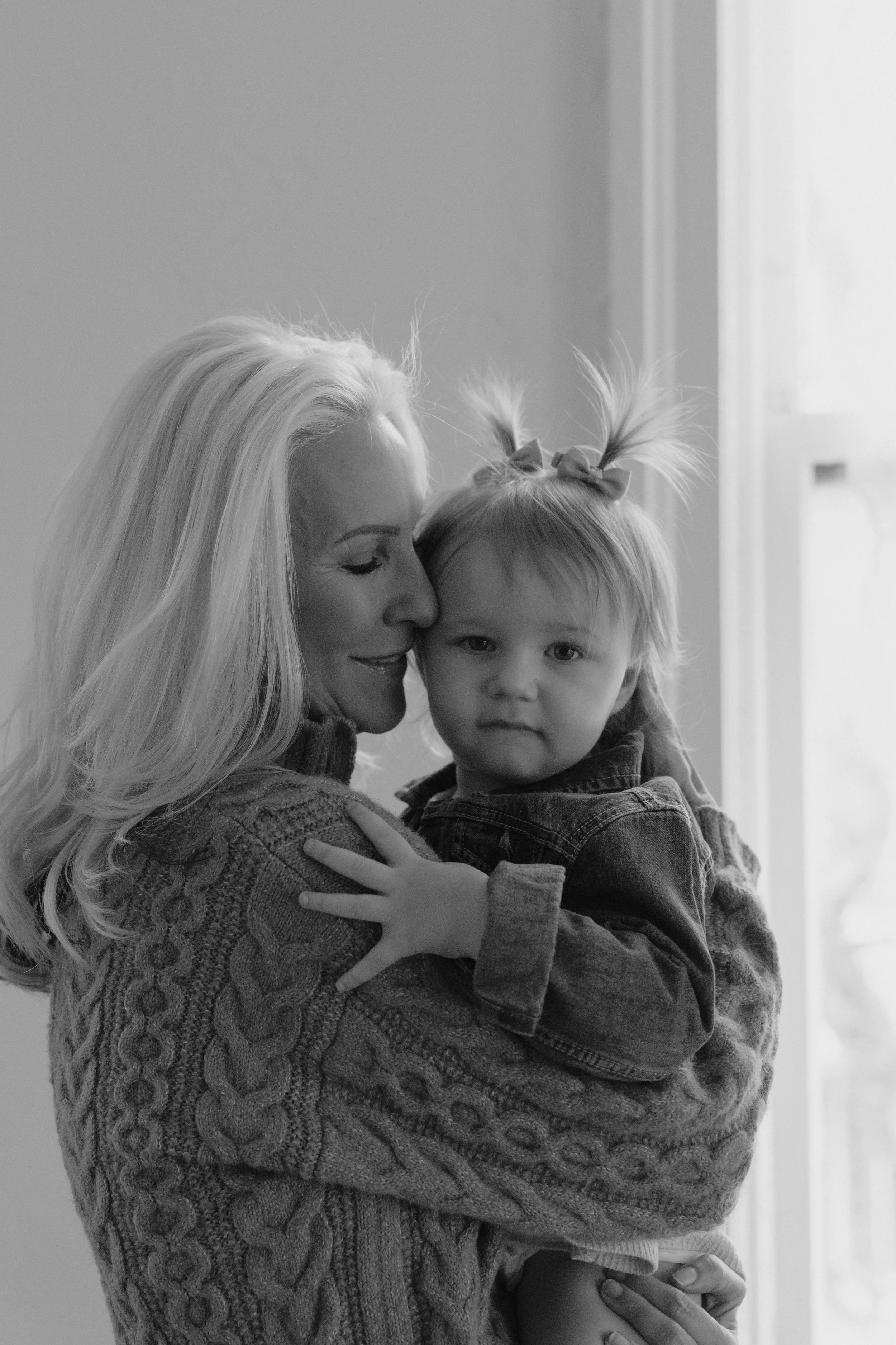 Grandmother cuddling her granddaughter close to her.