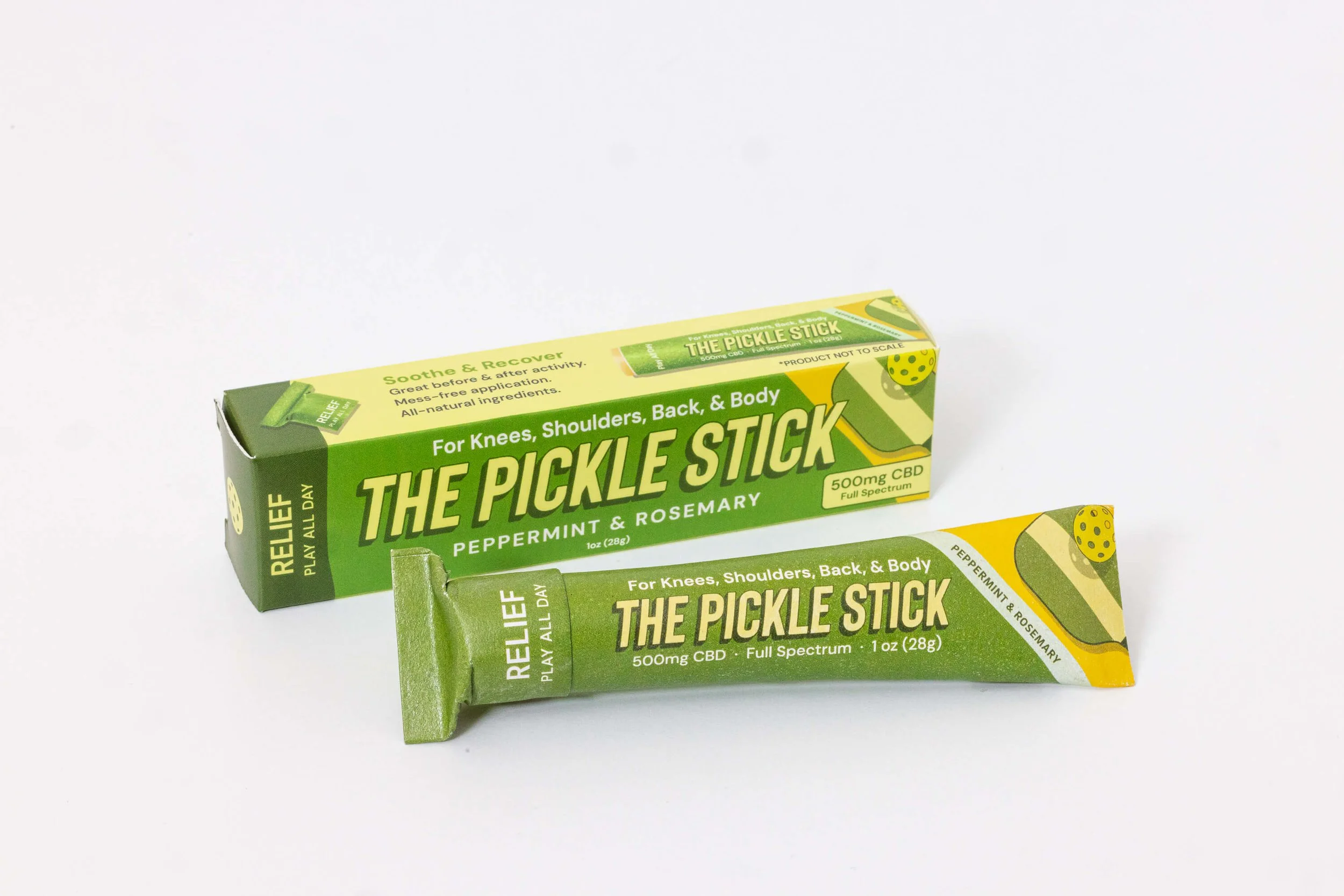 Scenic landscape of green rolling hills leading to a large turquoise lake with mountain peaks in the background under a cloudy sky.