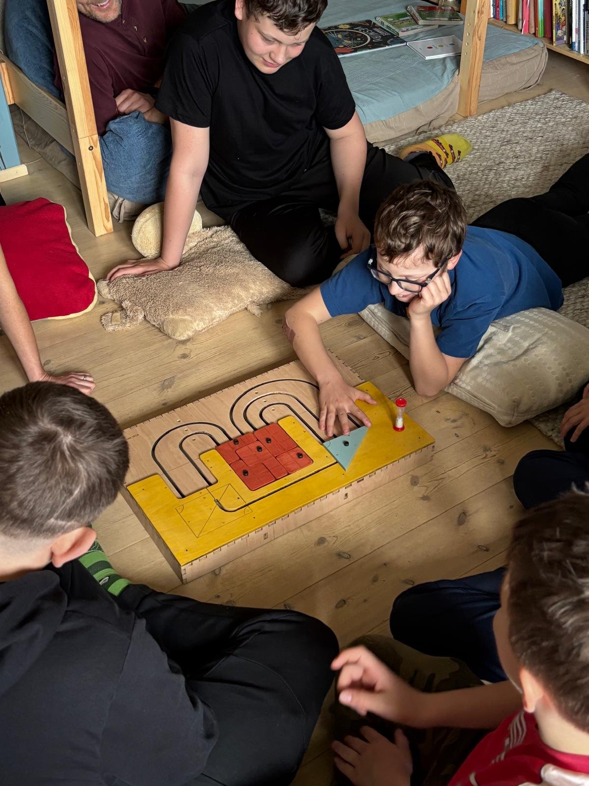 Group of kids playing a wooden puzzle game on the floor