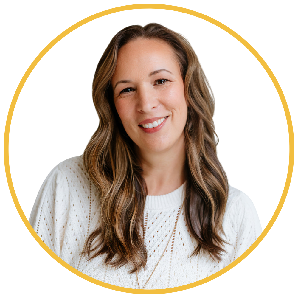 A woman with long wavy brown hair, smiling, wearing a white knit sweater, against a white background with a yellow circular border.