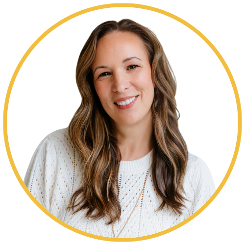 A woman with long wavy brown hair, smiling, wearing a white knit sweater, against a white background with a yellow circular border.