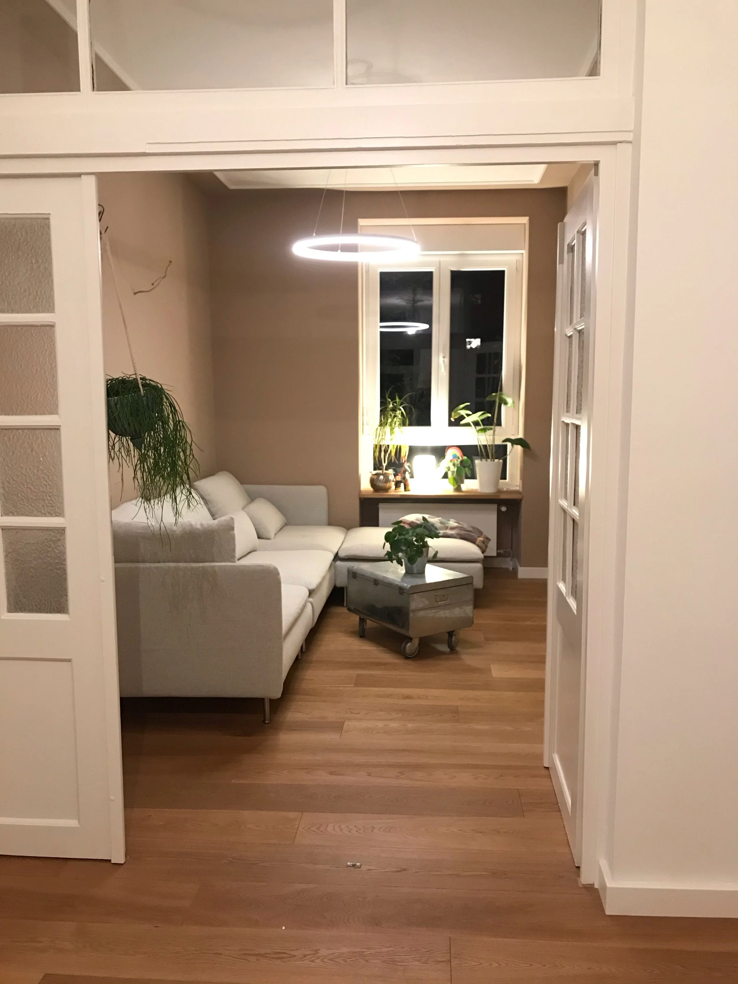 Blick in ein Wohnzimmer mit couch, Lmape und Fenster